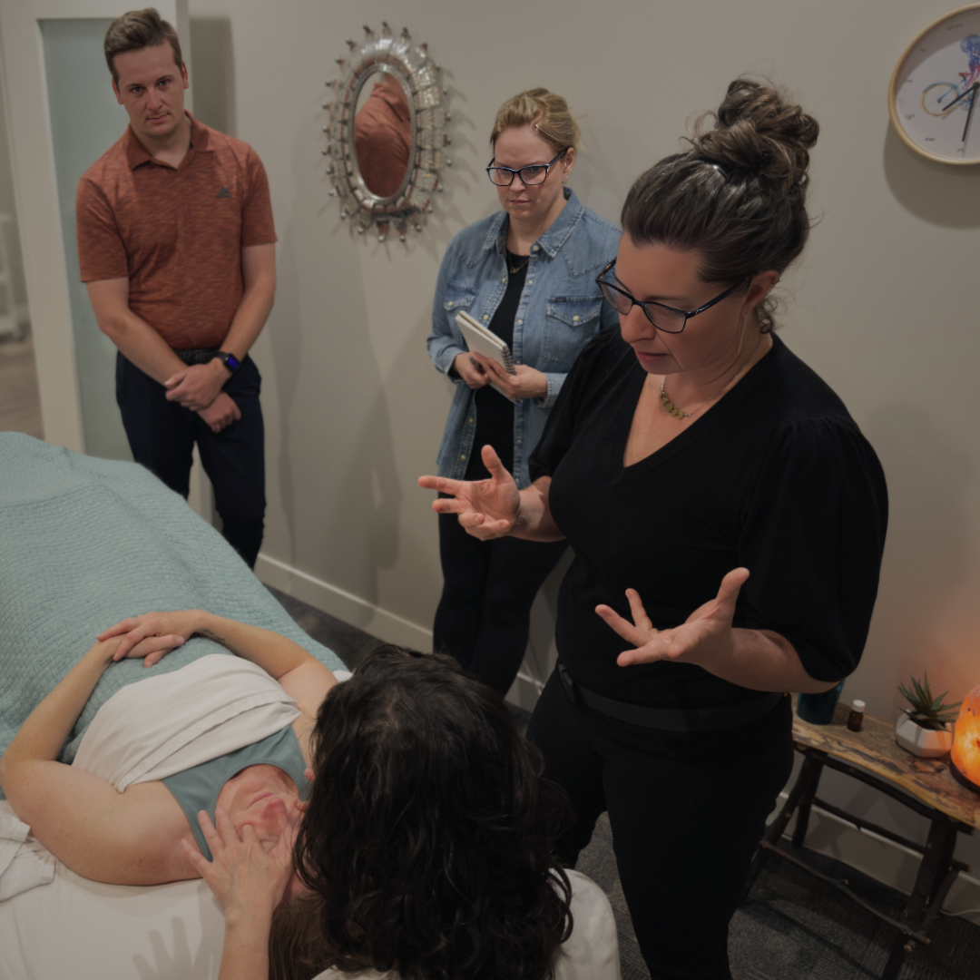 massage therapist teaching hands on skills to students