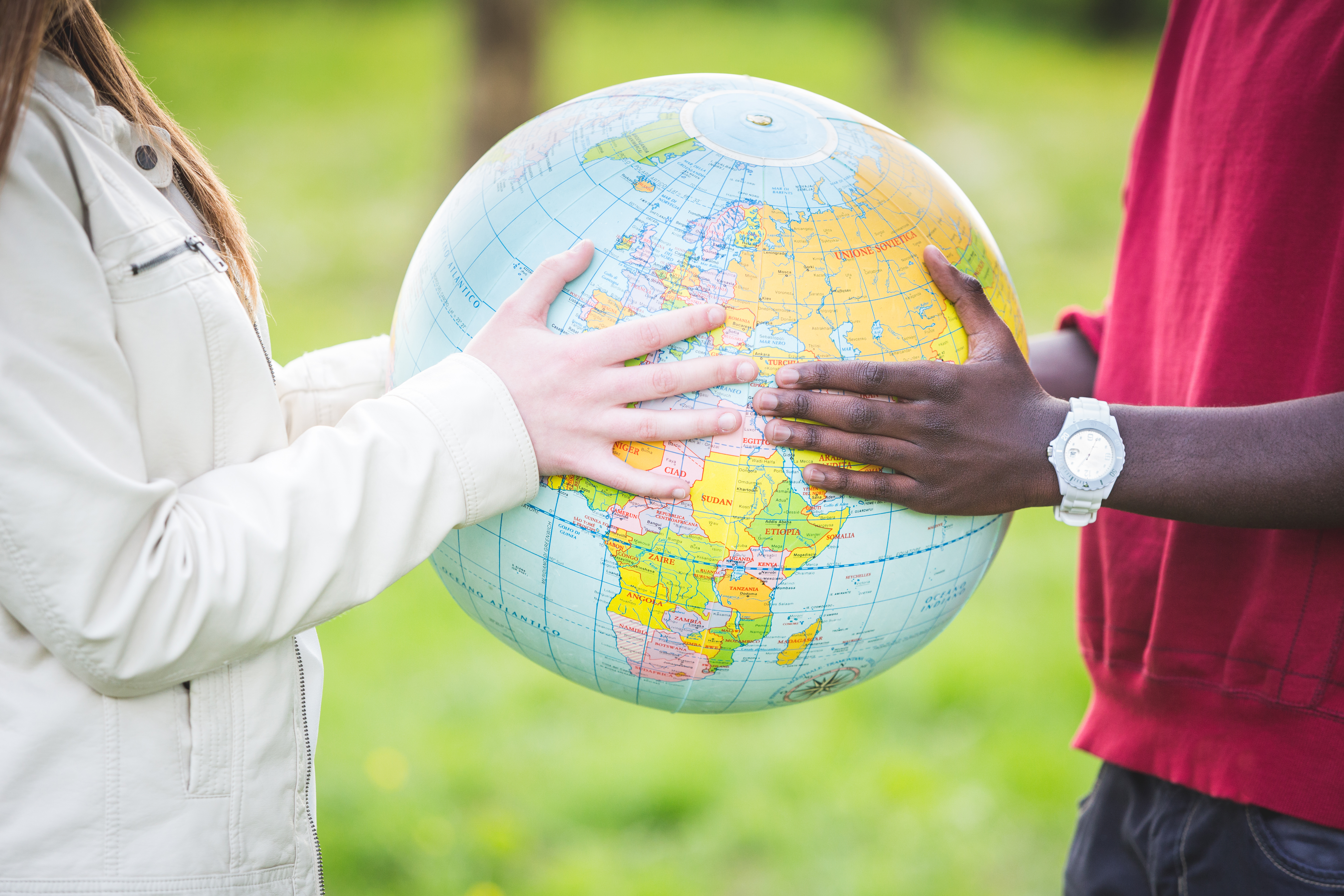 Multicultural people holing a globe of the world