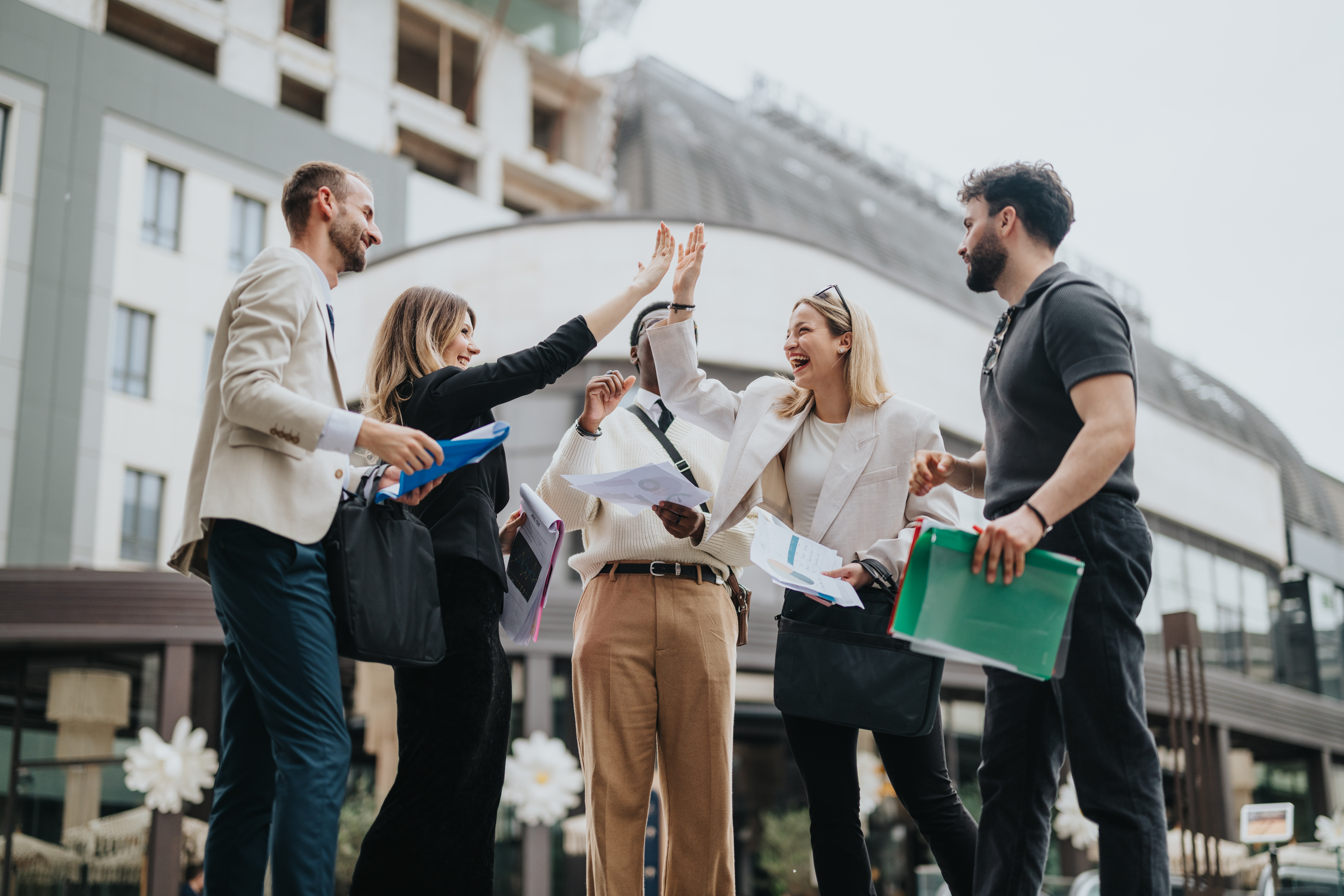 Group of business colleagues high-fiving and smiling