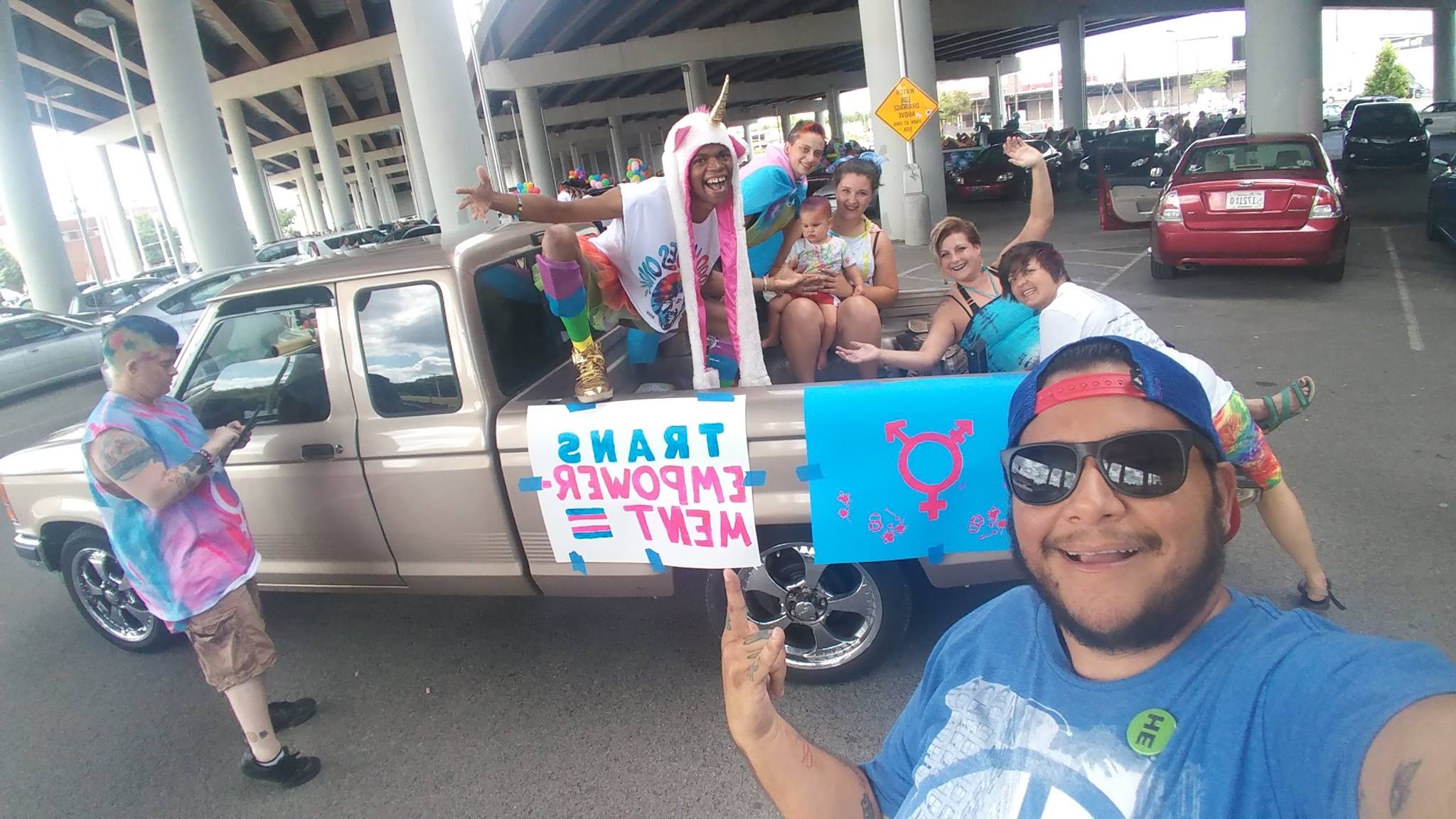 A group of volunteers is seen smiling and posing ahead of a pride day event for TEP