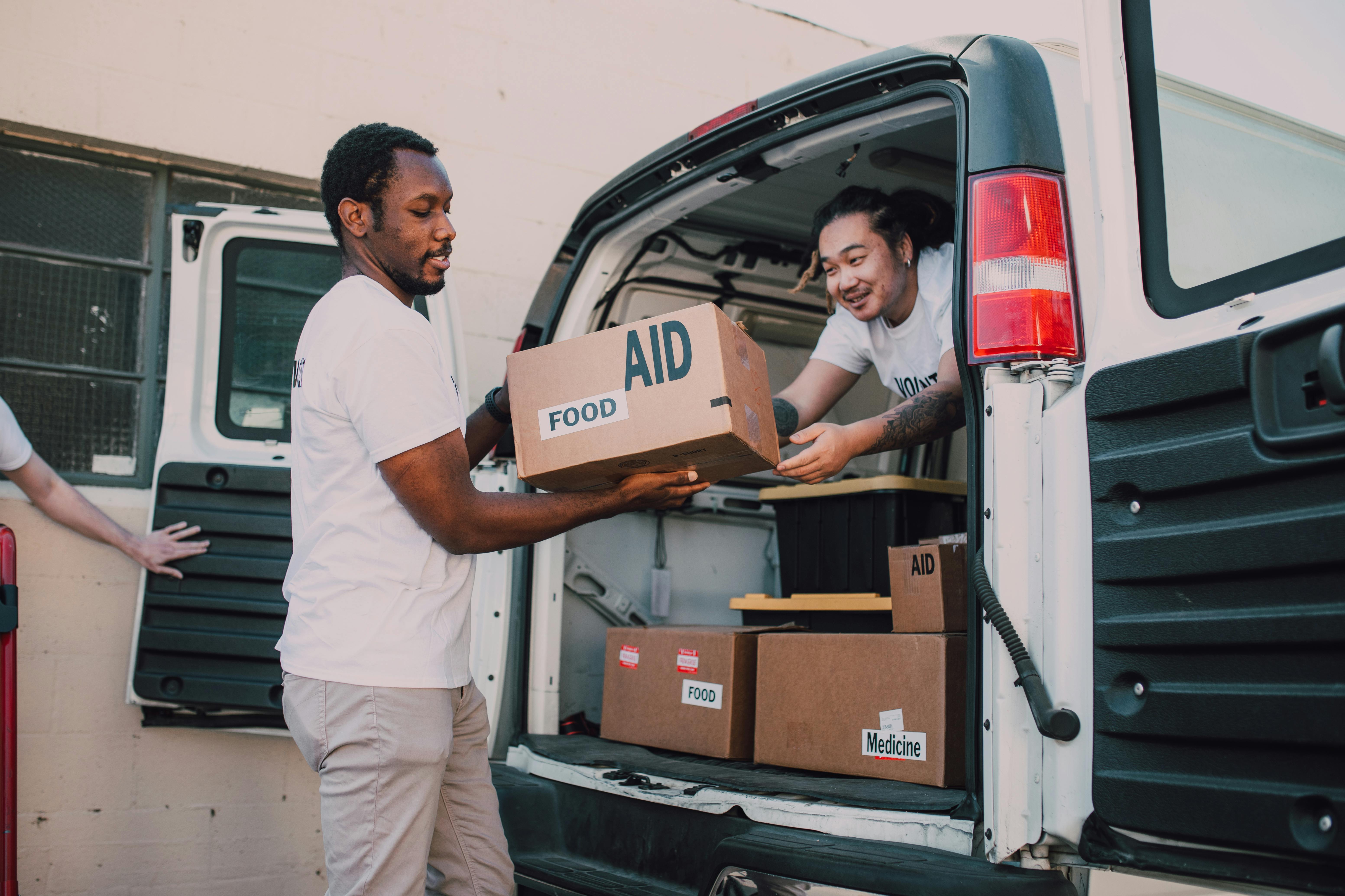Volunteers are seen assisting each other with food packages