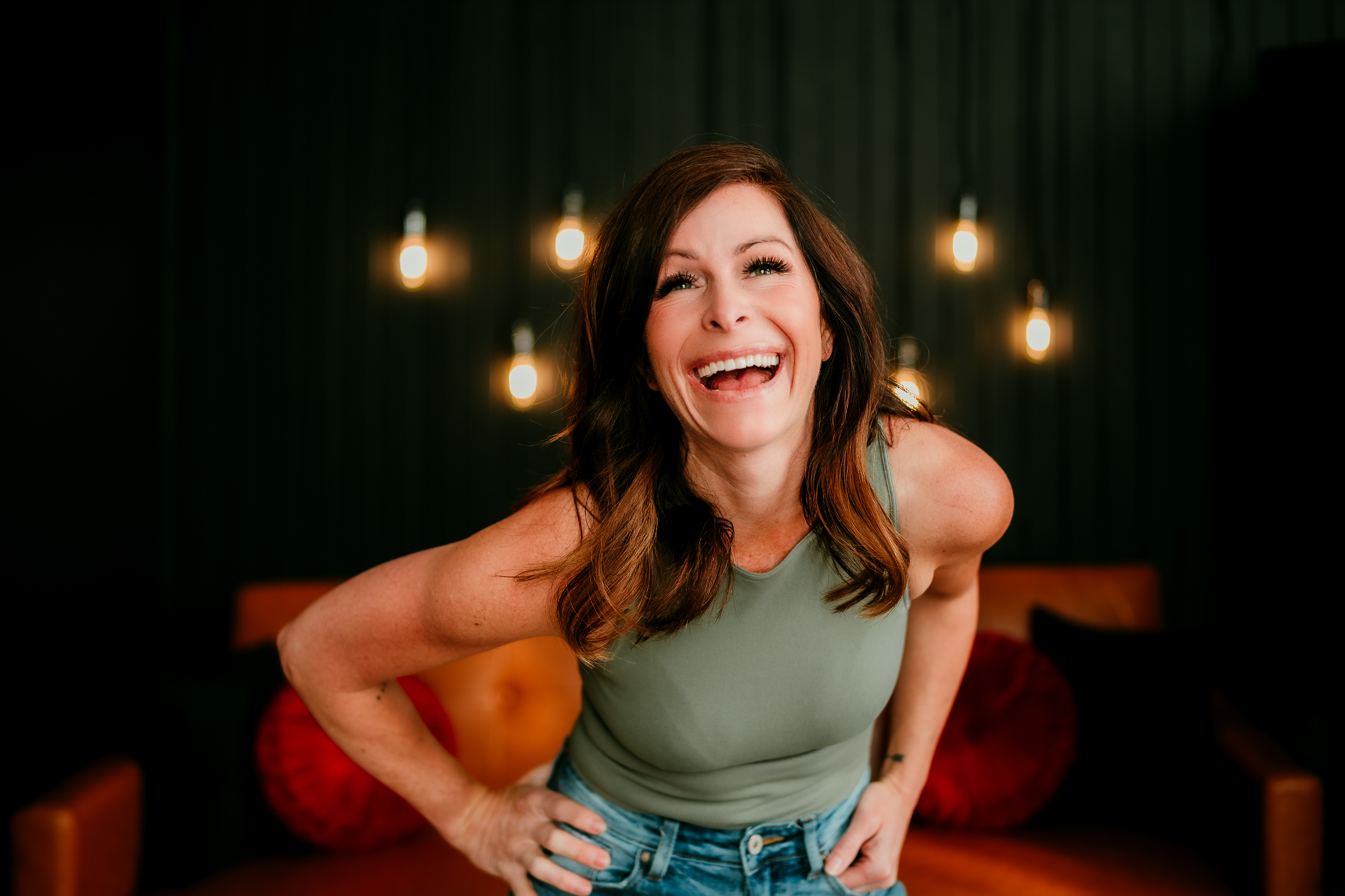 Shannon O'Malley, Twin Cities online dating and portrait photographer, smiling in a warmly lit studio — capturing her confident, magnetic, and authentic style.