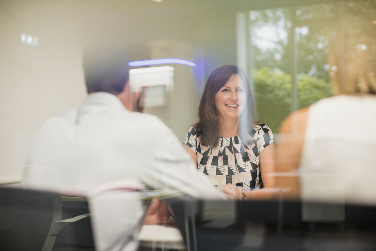 a smiling woman in an office meeting