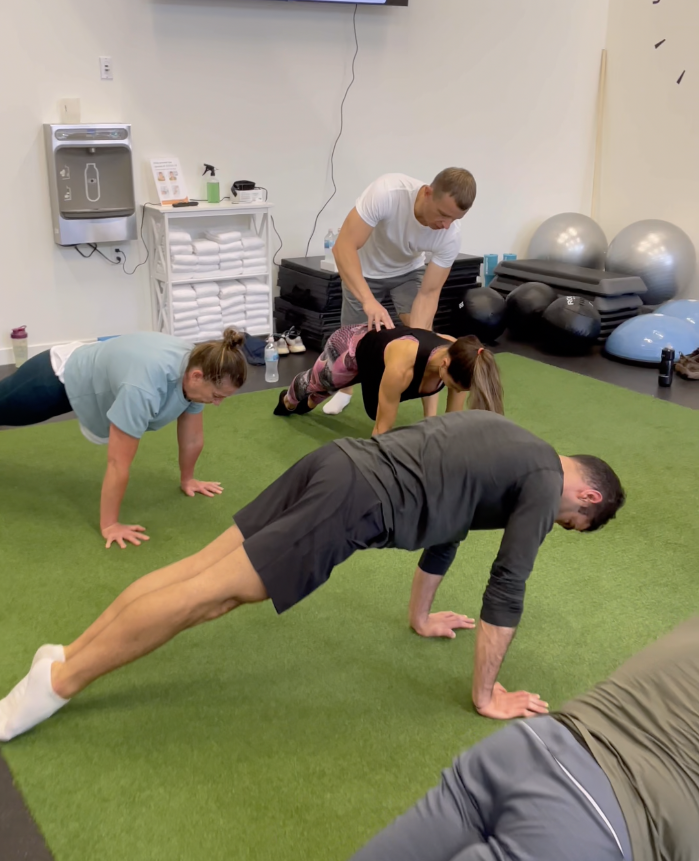 Trainer Maxim correcting a student's plank form.