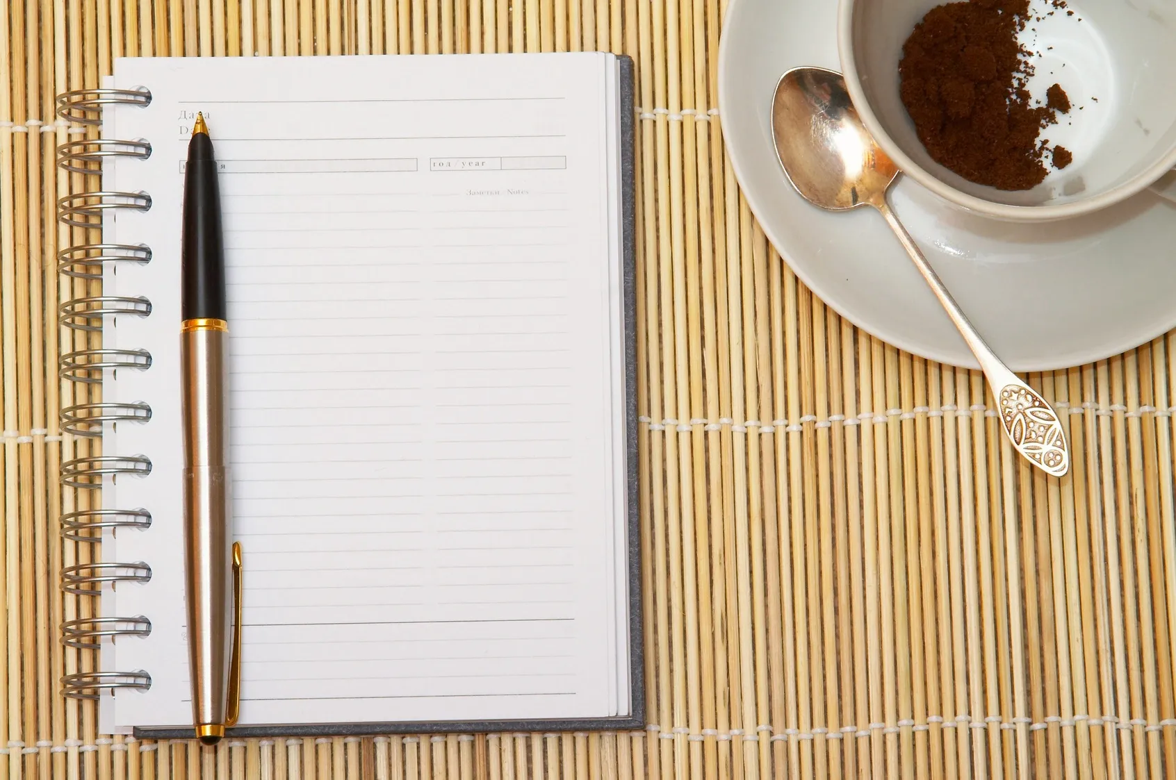 Notepad and pen, with coffee cup nearby.