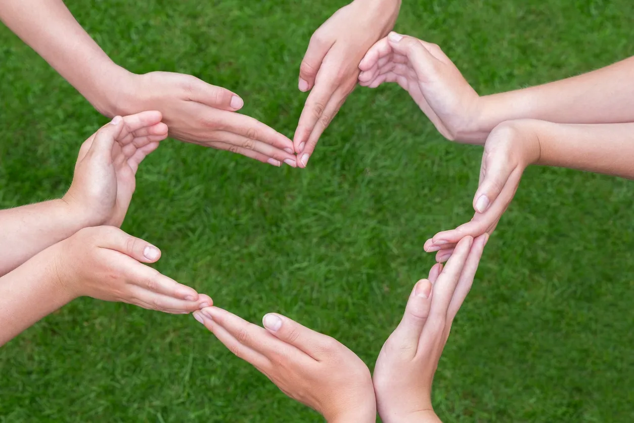 3 sets of hands interlinked to make heart shape.