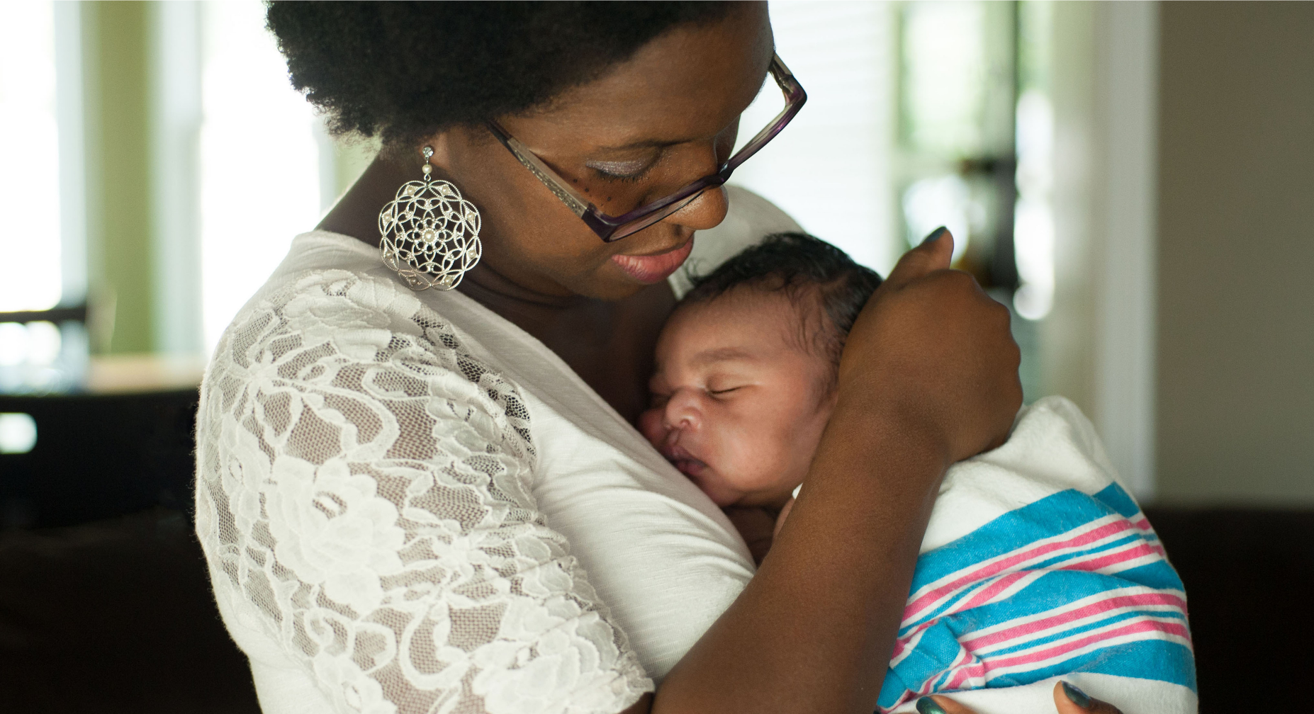Postpartum doula care training image showing a mother holding her newborn baby, illustrating bonding, attachment, and nurturing newborn support in the postpartum period.