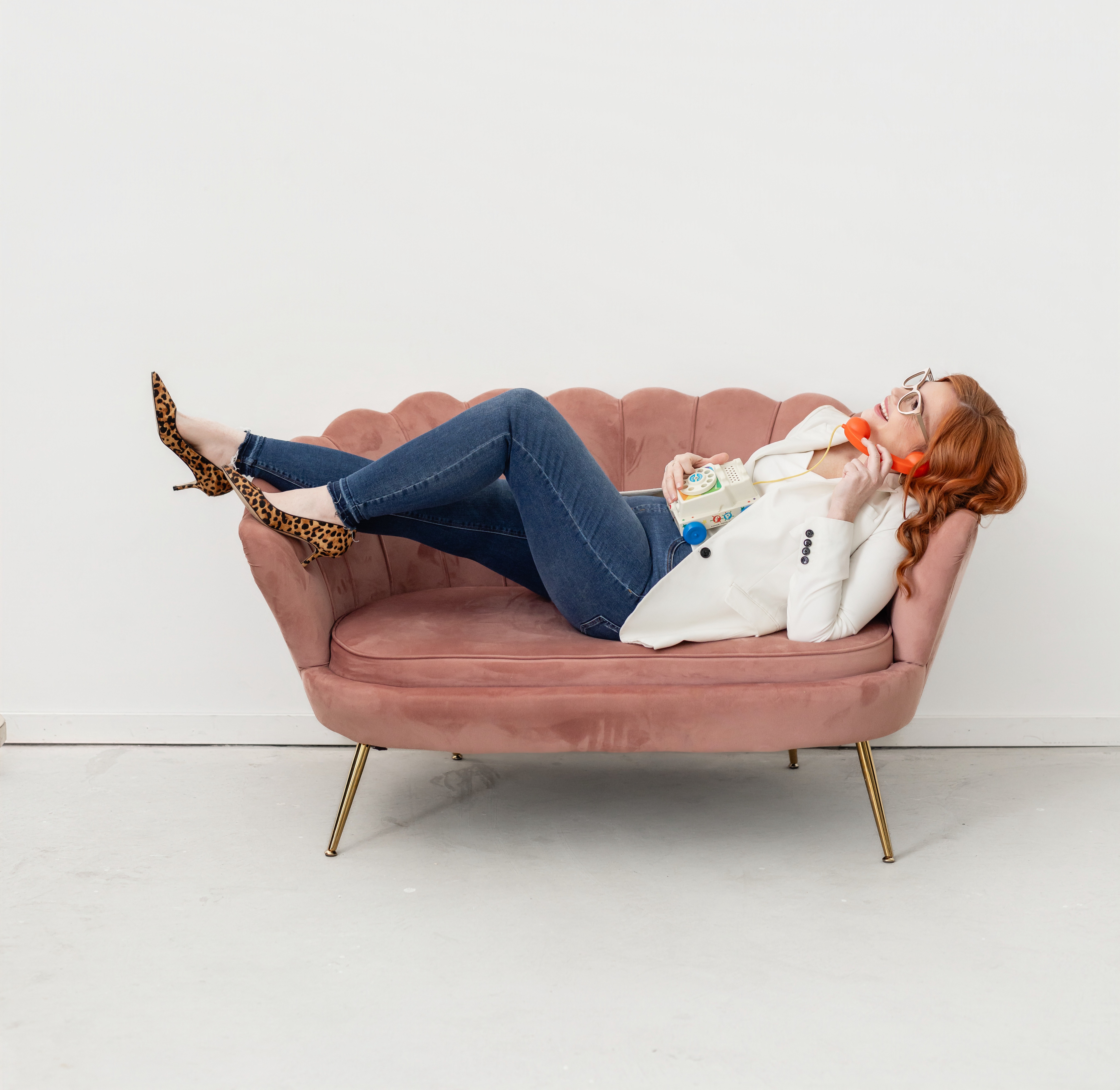 woman on telephone laughing on a couch