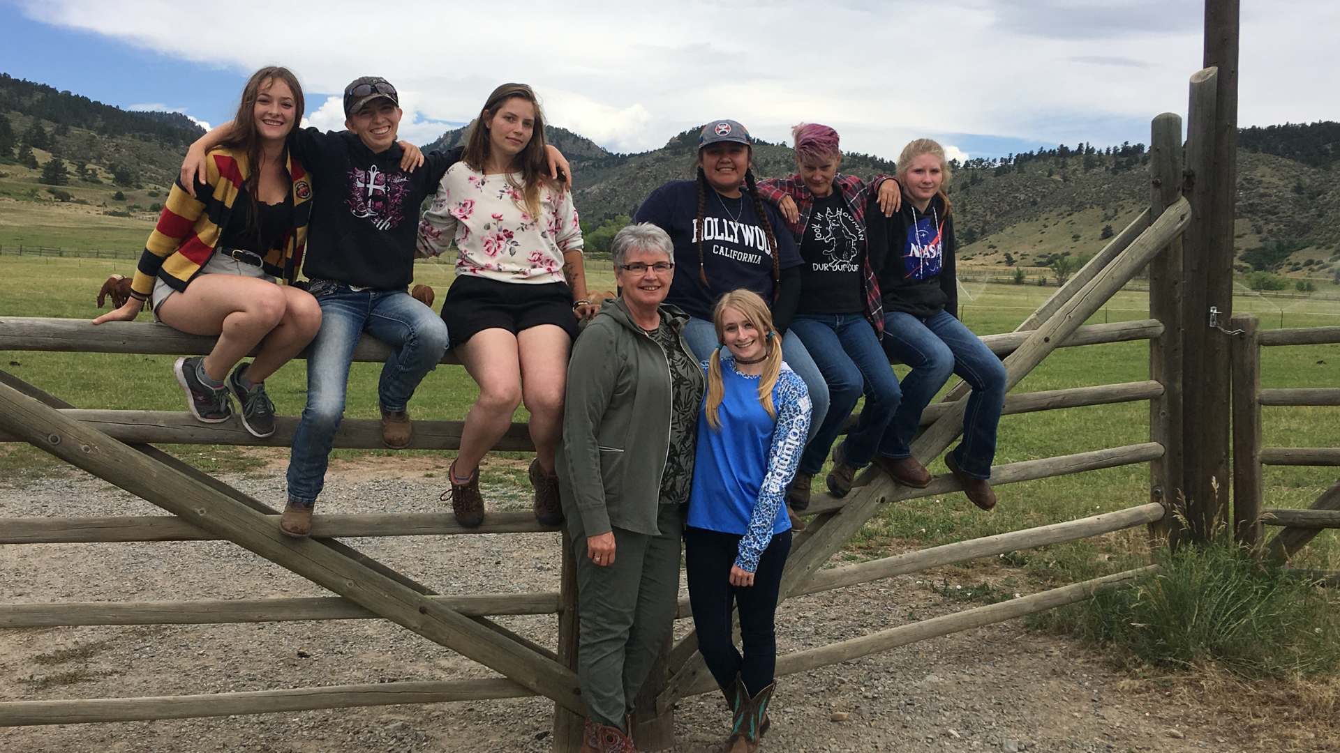 Students with their mentor through the Willowbrook Academy sitting on a Gate