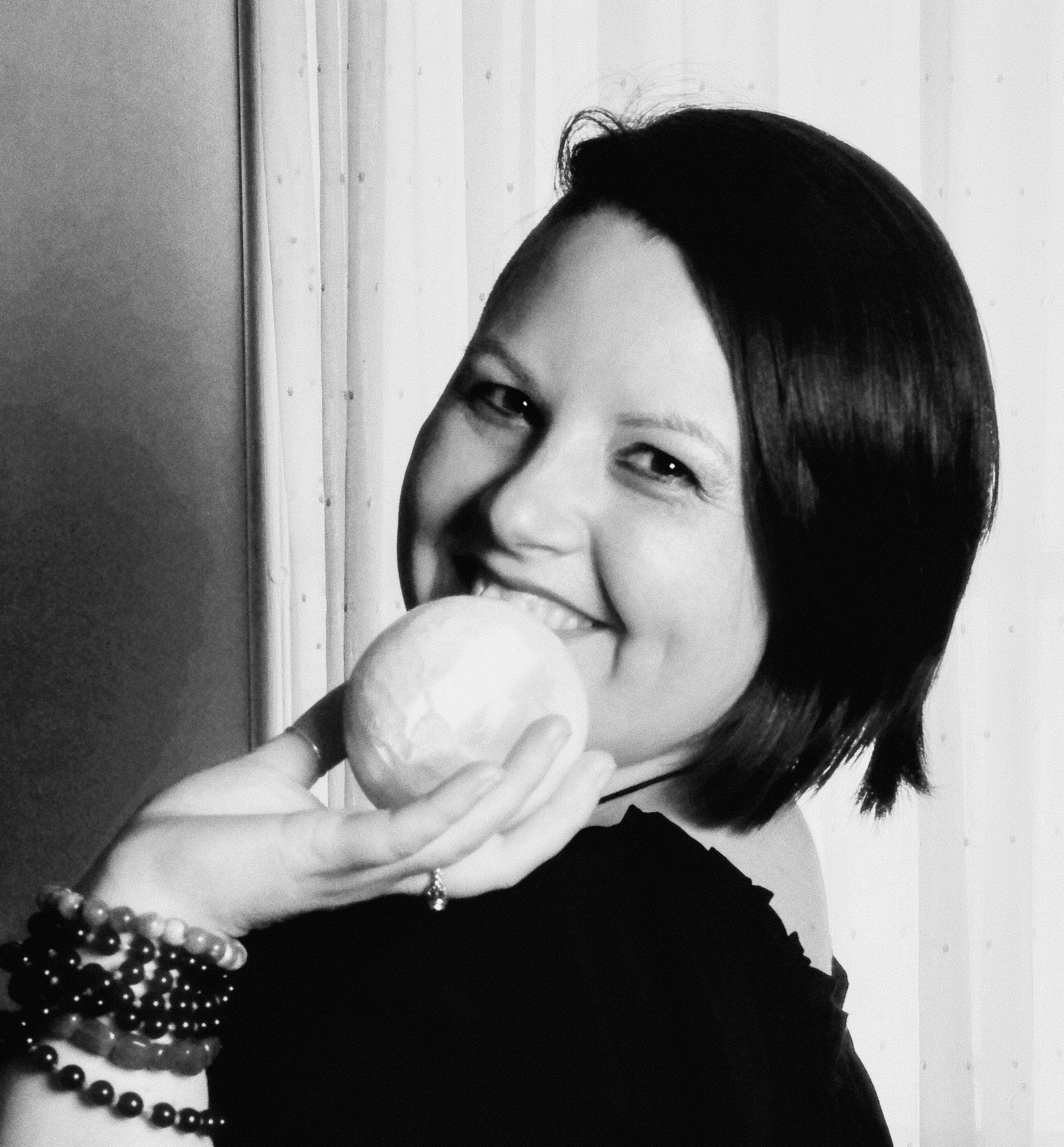 Photograph of Evylyn Rose, Empowerment Guide and Tarot Reader. She is smiling and holding up a selenite crystal ball.
