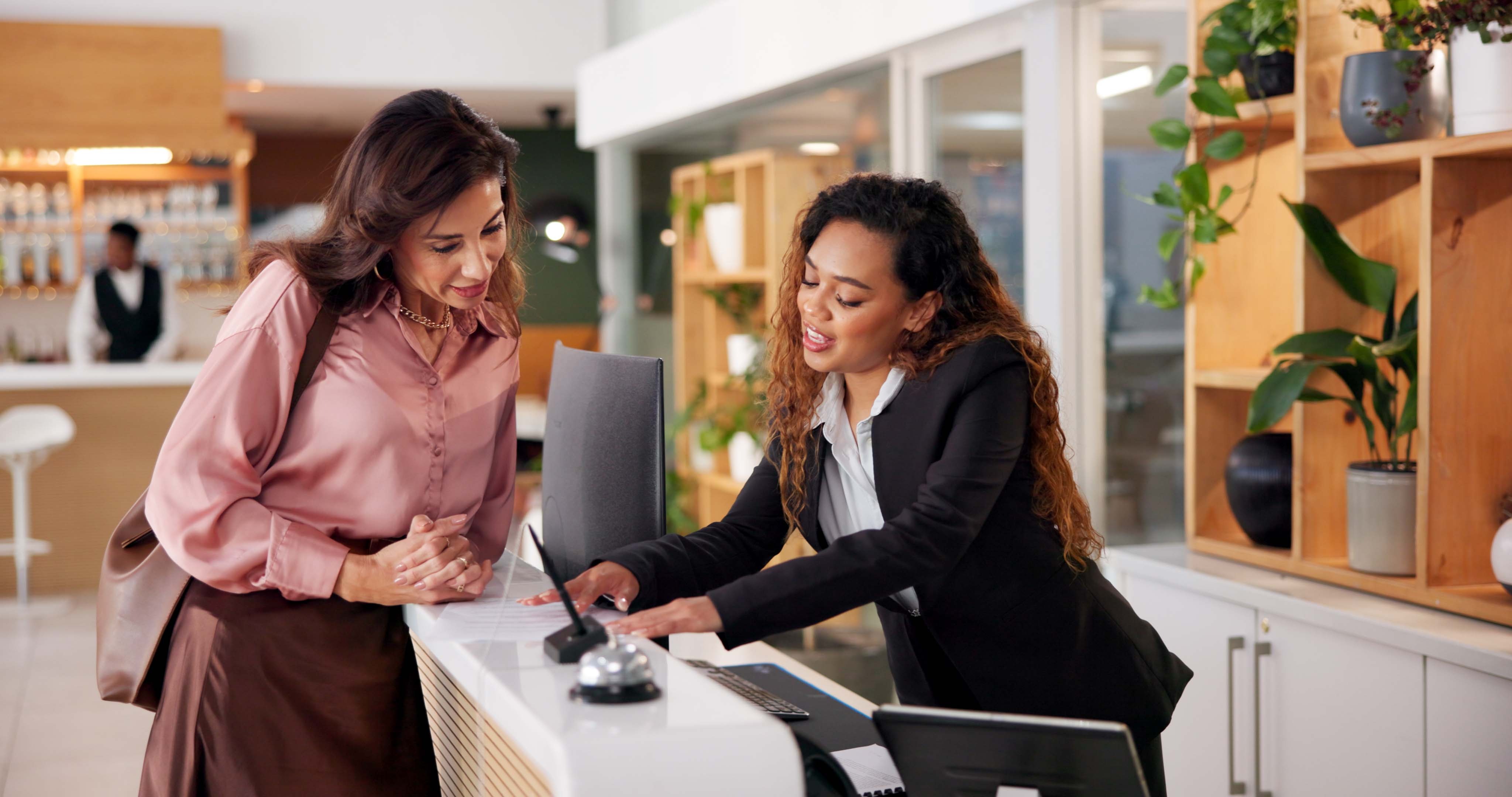 Hospitality professionals assisting guests at a modern hotel reception
