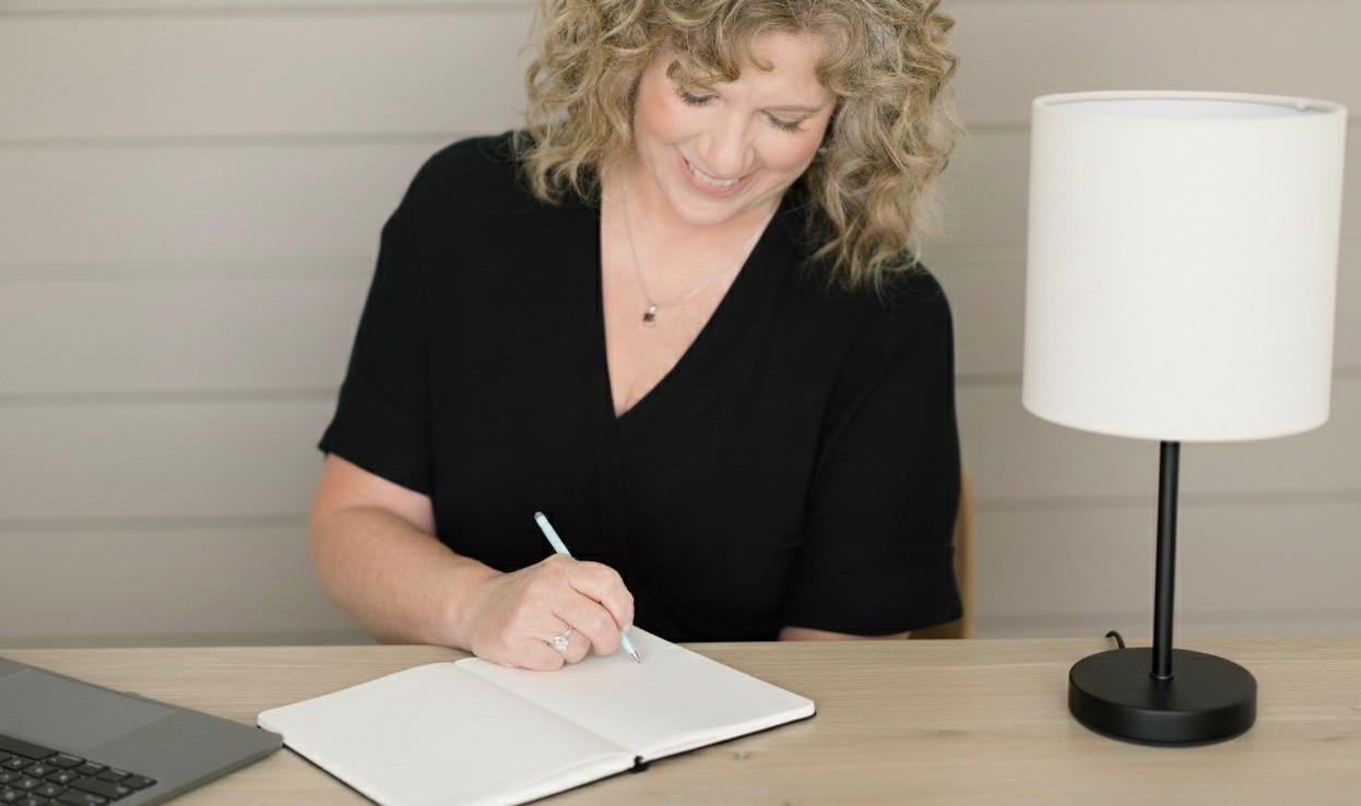 Therapist sitting at desk writing notes