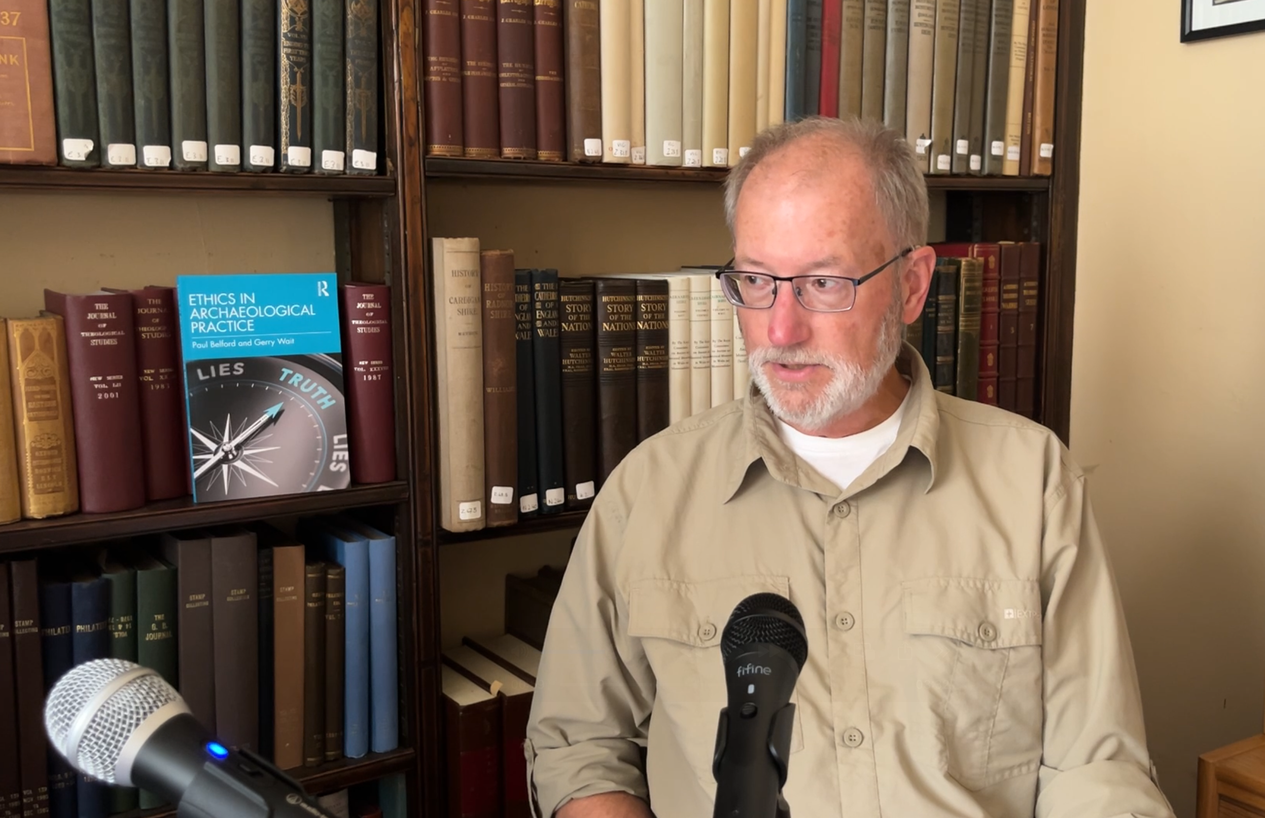 Dr Gerry Wait speaking in front of a bookcase