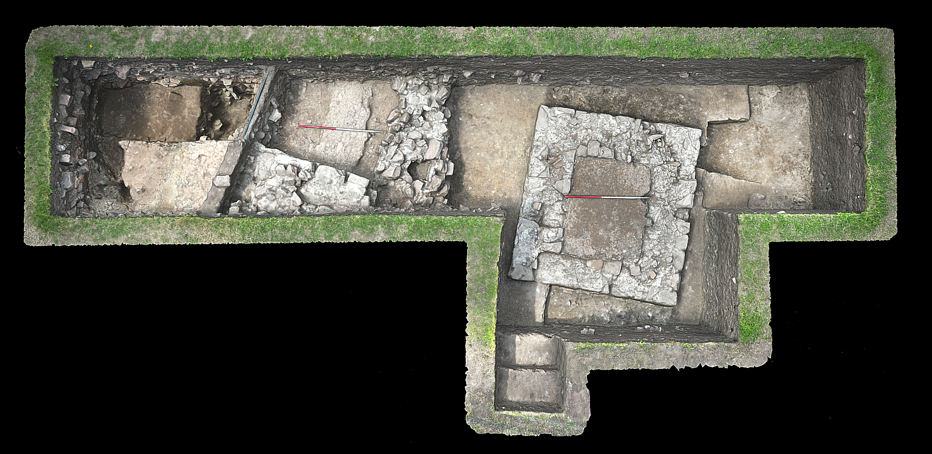 Vertical aerial view of an archaeological trench with structures and surfaces