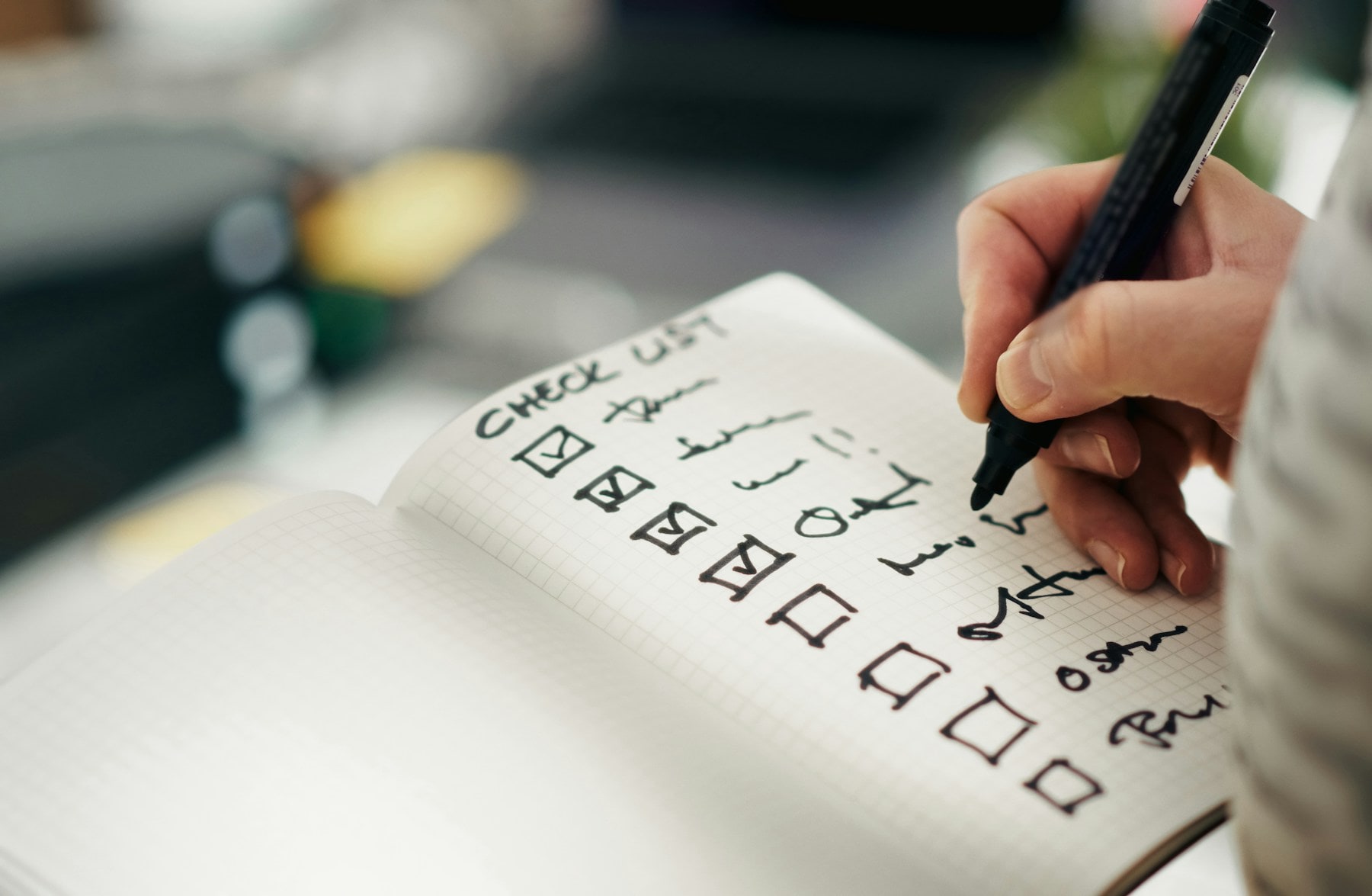 A hand marking a provider early-warning checklist on paper.