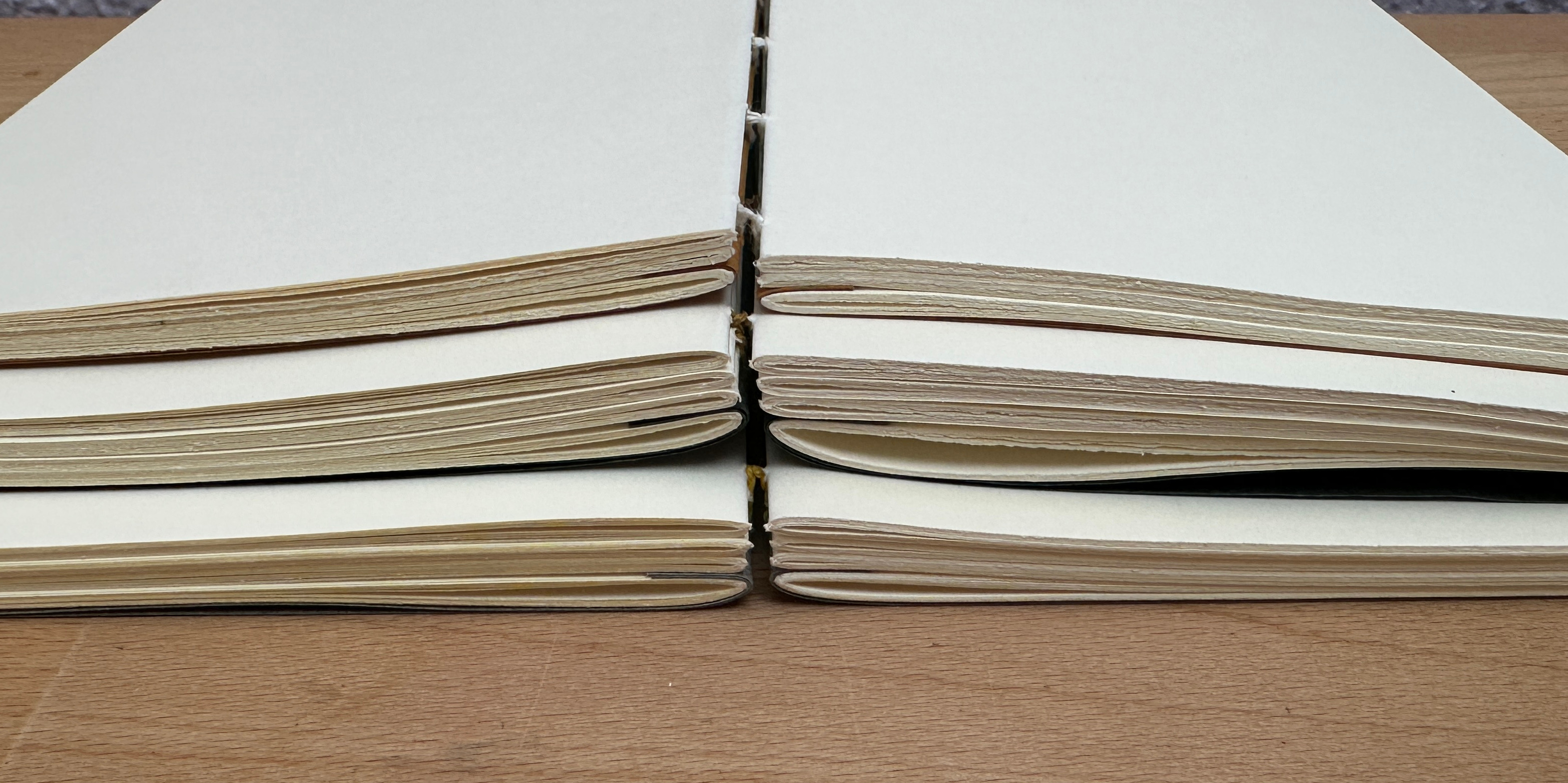 Three books stacked on top of each opened flat.