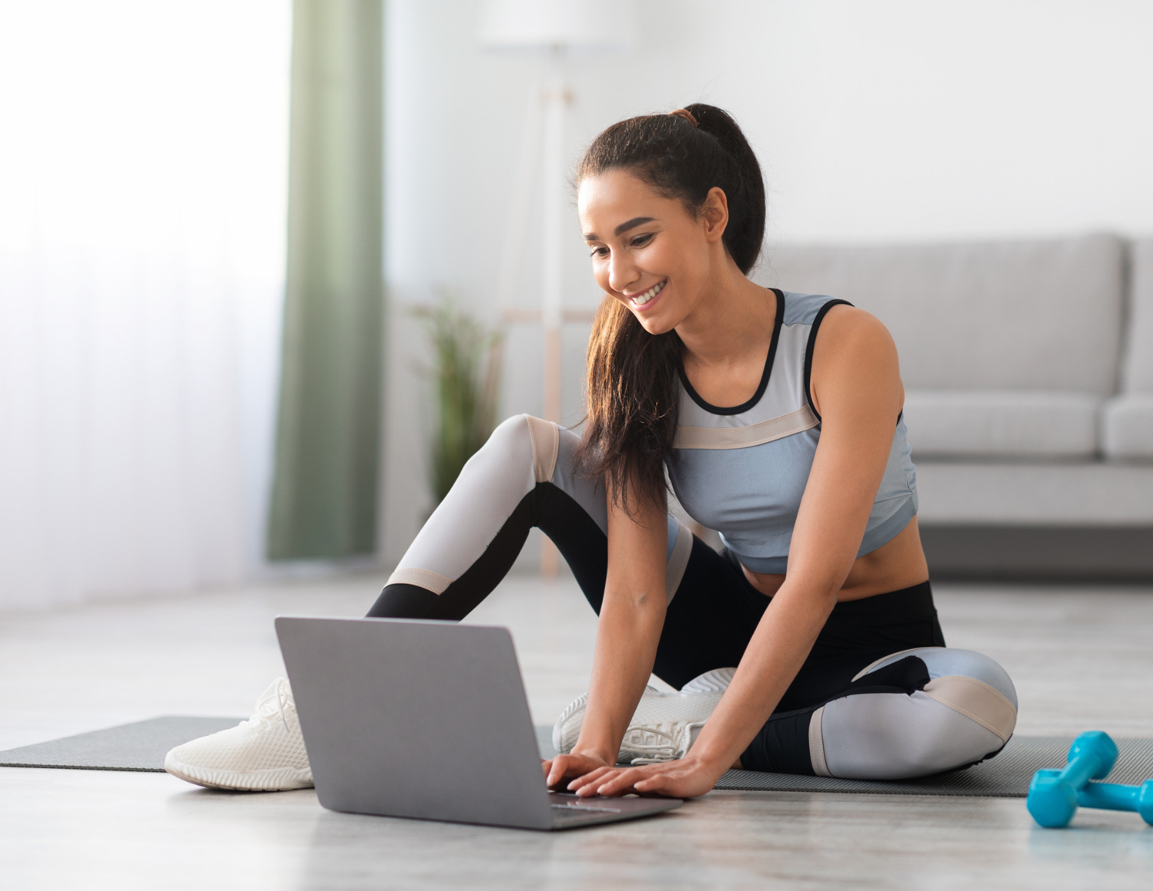 Woman at home in workout clothes on her computer