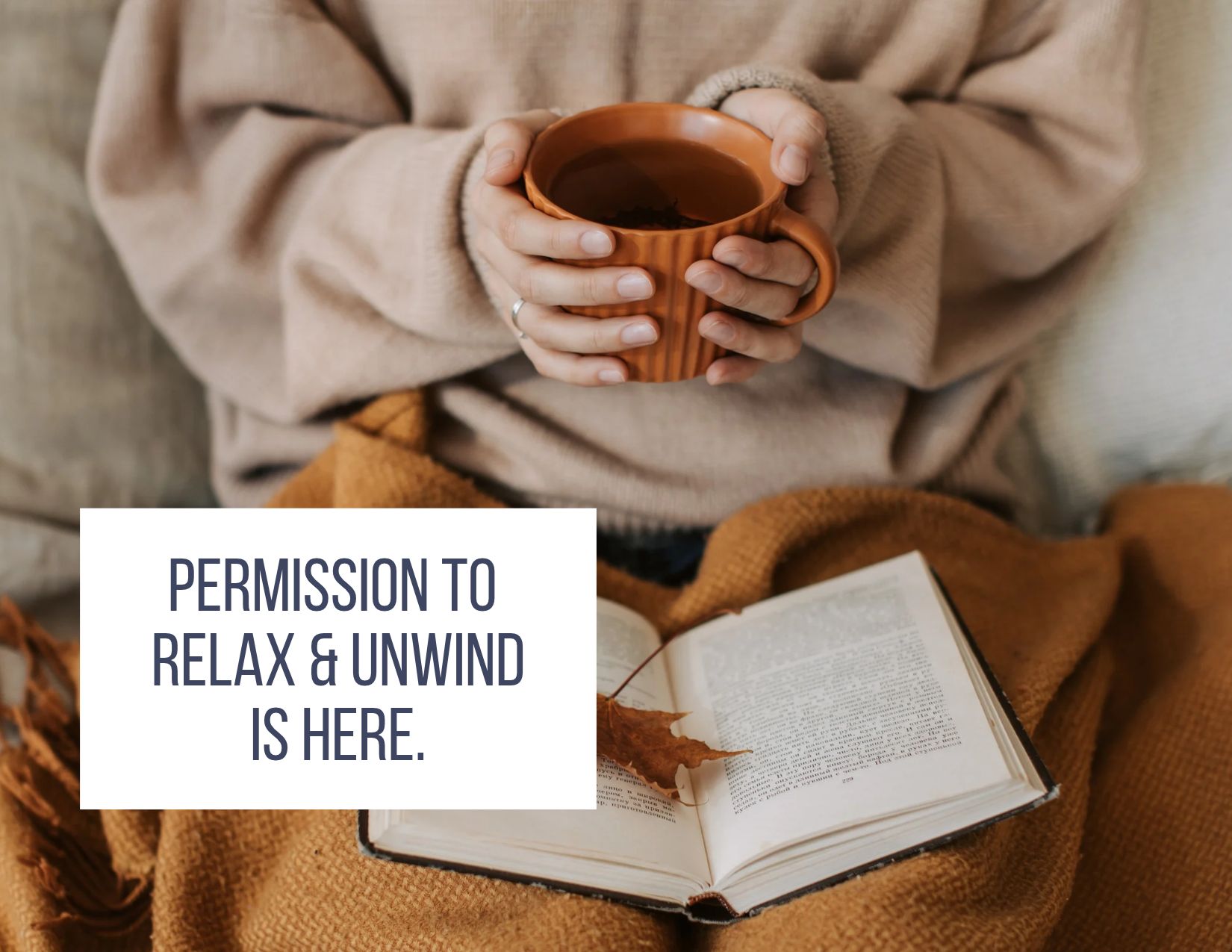person holding cup of tea with blanket and book