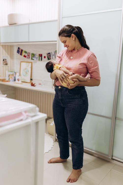 A parent cradling a newborn at home.