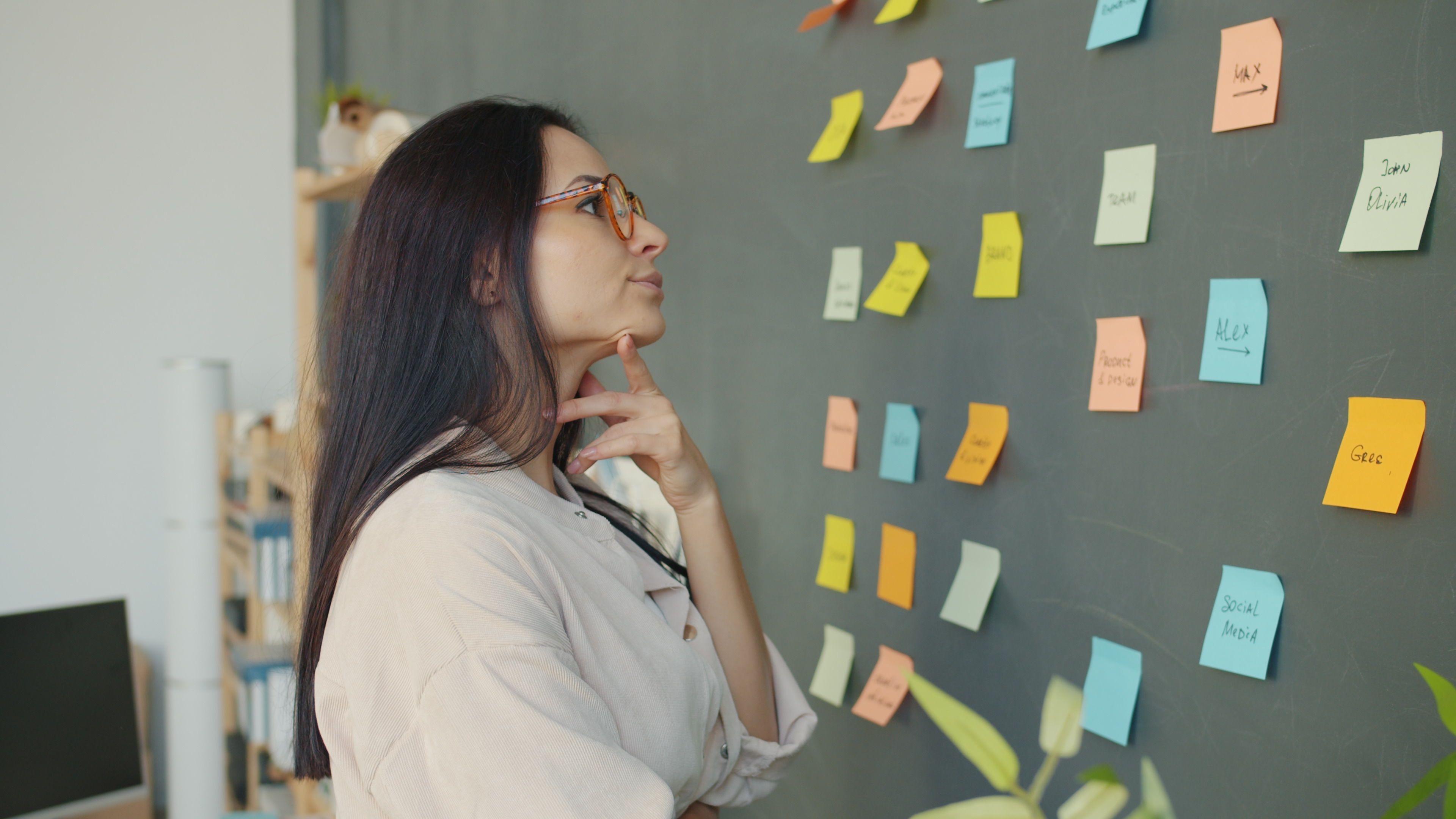 woman staring at wall full of post-it notes 