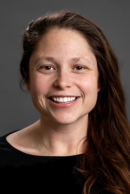 smiling woman with long hair and brown eyes