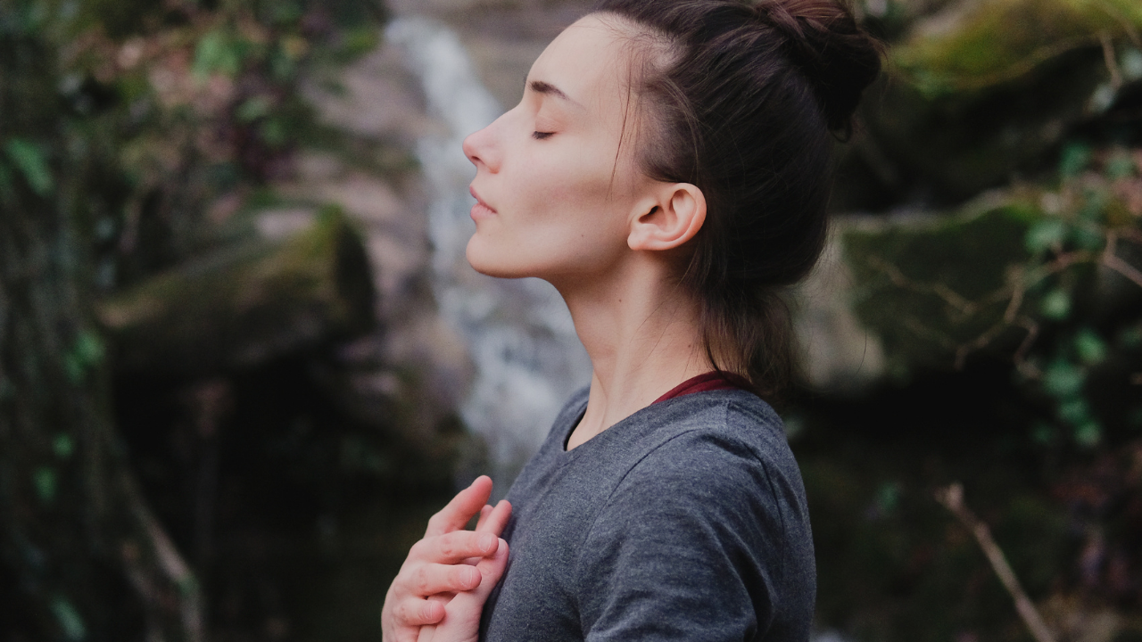 woman with eyes closed in nature in meditation 