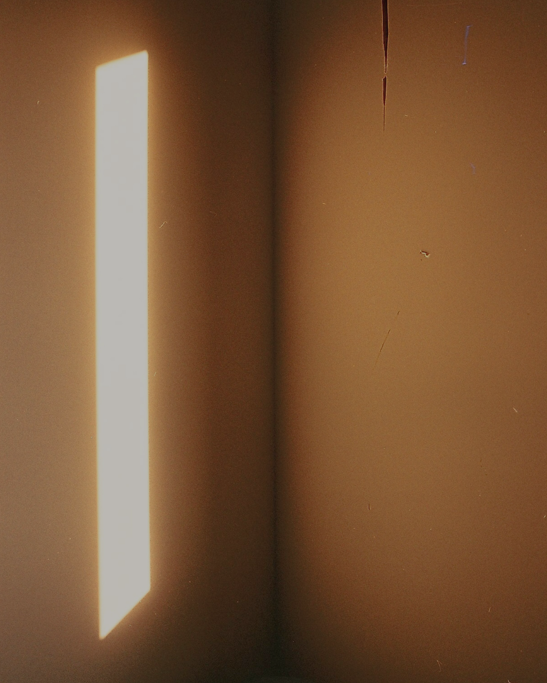 corner of a room with light on wall