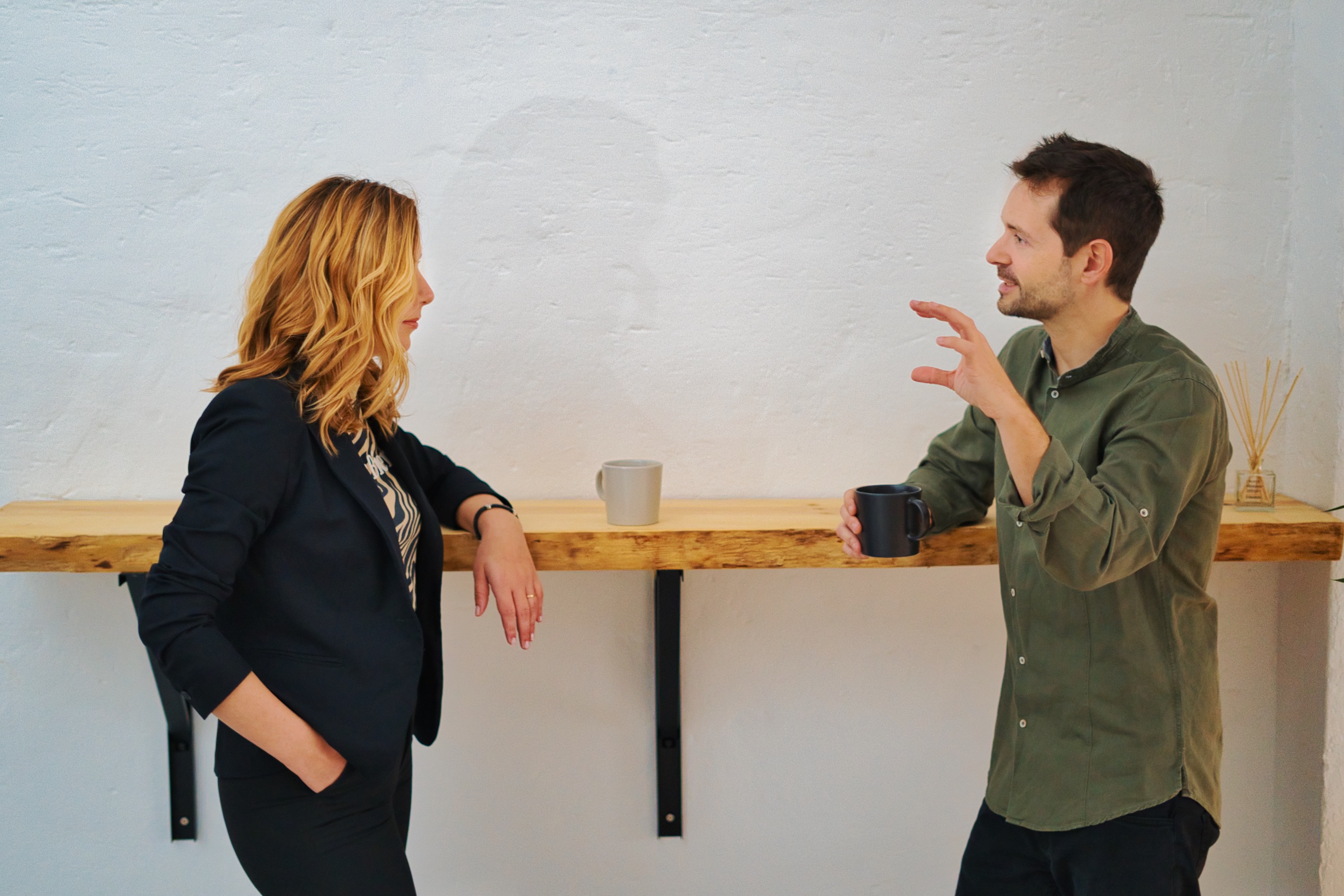 Alba Álvarez y Guillermo Matía, fundadores de Delegate Solutions, conversando de pie junto a una barra de madera