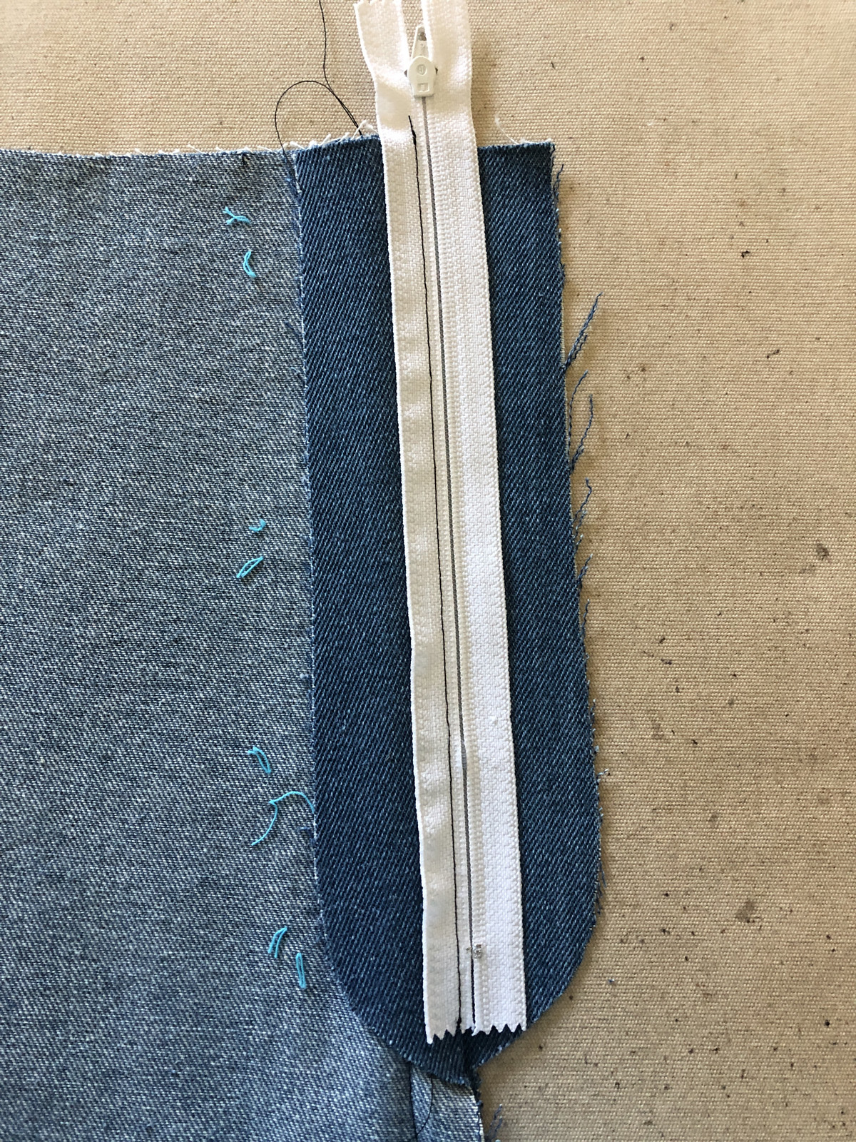 Lay the zipper on the mock fly extension