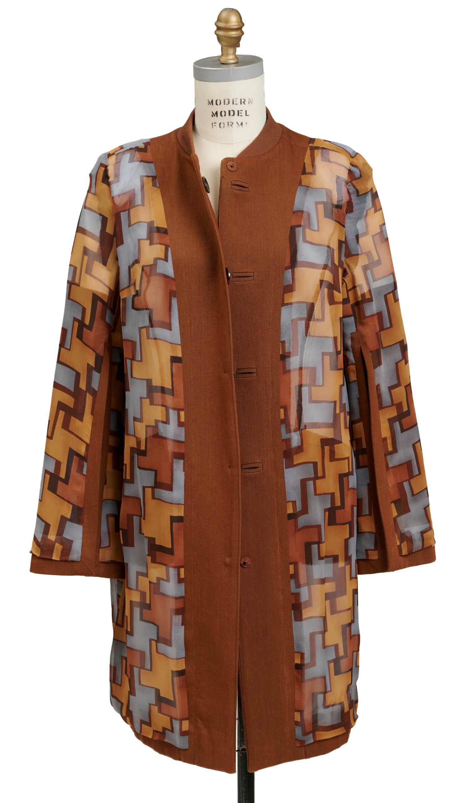 A view of hidden buttoning on a coat hanging inside out on a dress form