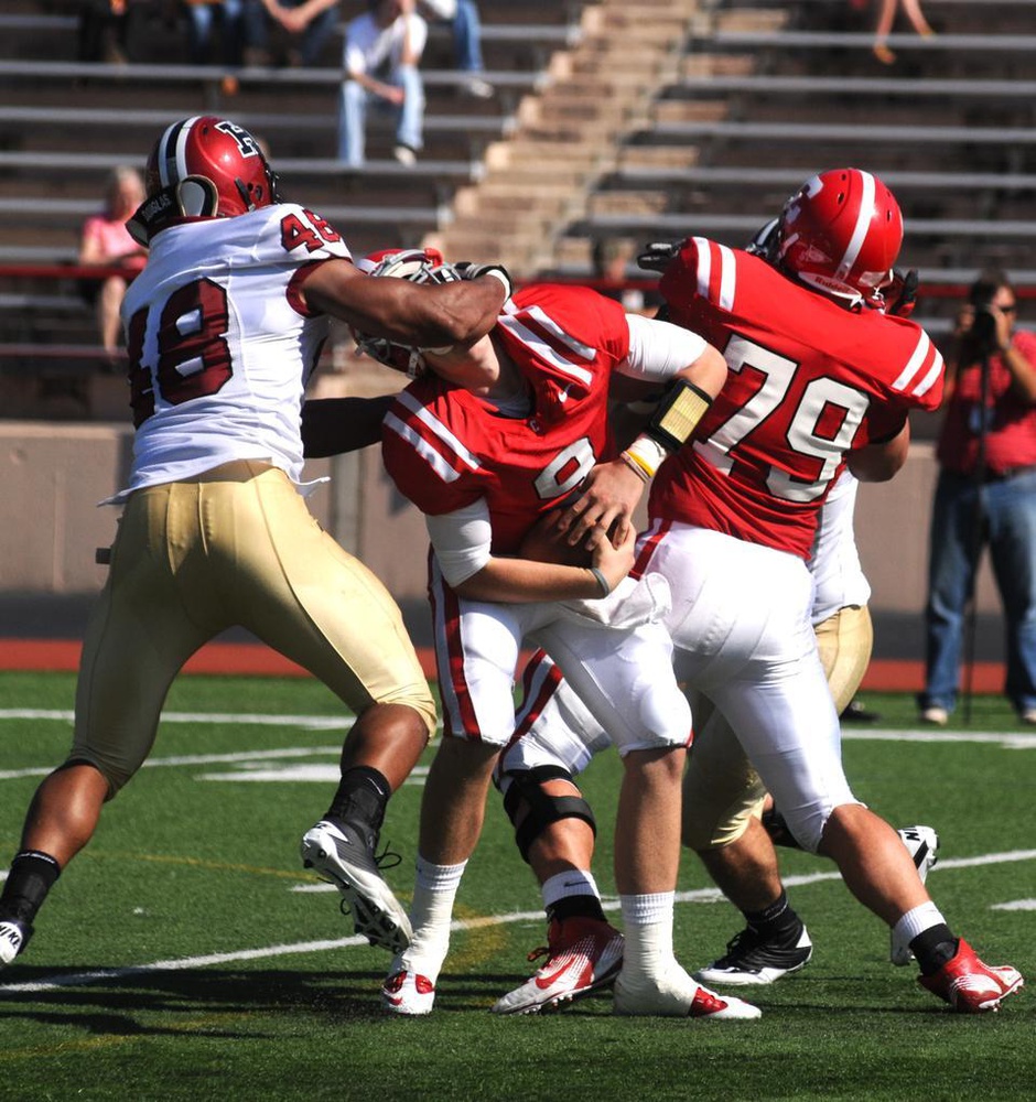 Senior defensive tackle Josue Ortiz, left, sacks Cornell QB Jeff Mathews in the Crimson's win over the Big Red on Oct. 9. Both players were deemed worthy of the Asa S. Bushnell Cup, an accolade for the Ivy League's most valuable player, on Monday. 