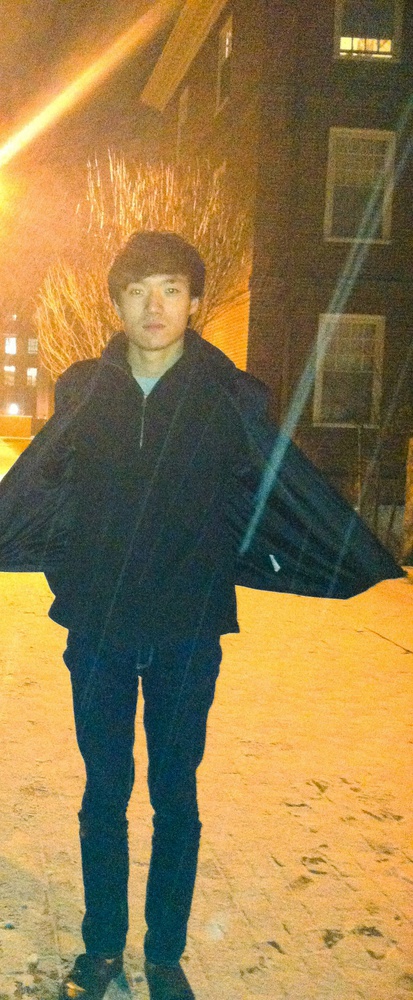 Eldo Kim poses in Quincy House courtyard during the season's first measurable snowfall on Dec. 9. Kim, a sophomore in Quincy, will appear in court on Wednesday for charges related to the bomb scare that disrupted final exams on Monday.