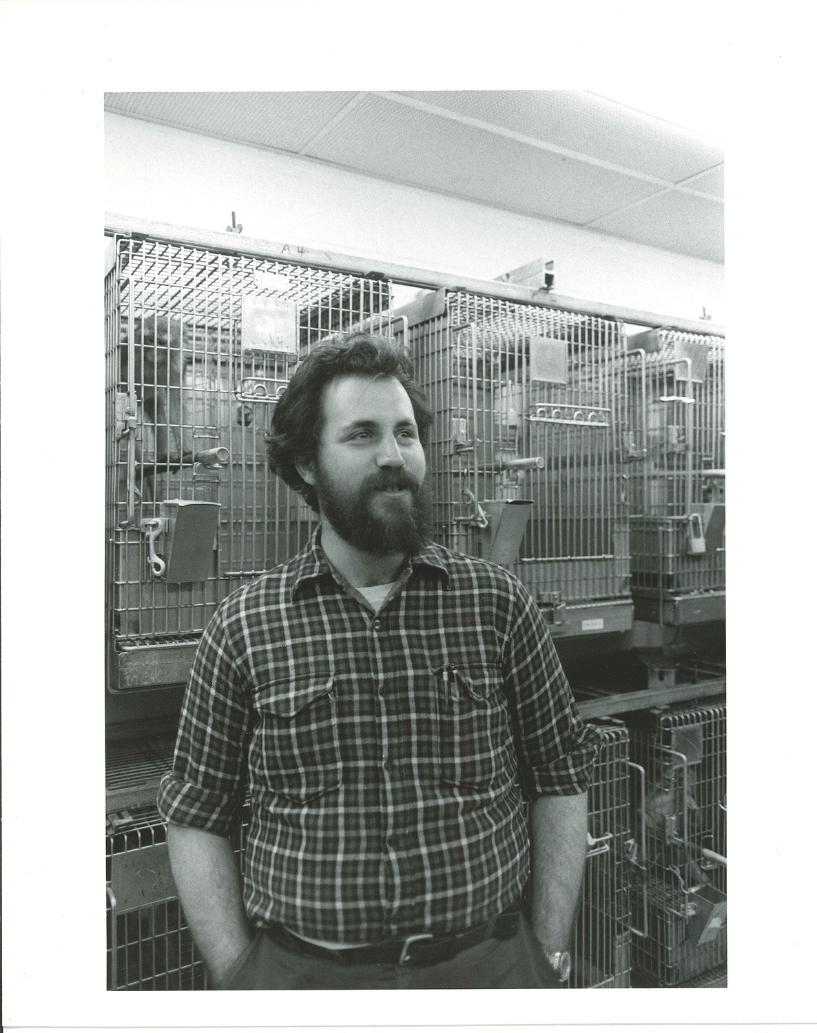 A worker at the NEPRC stands before a row of primates.