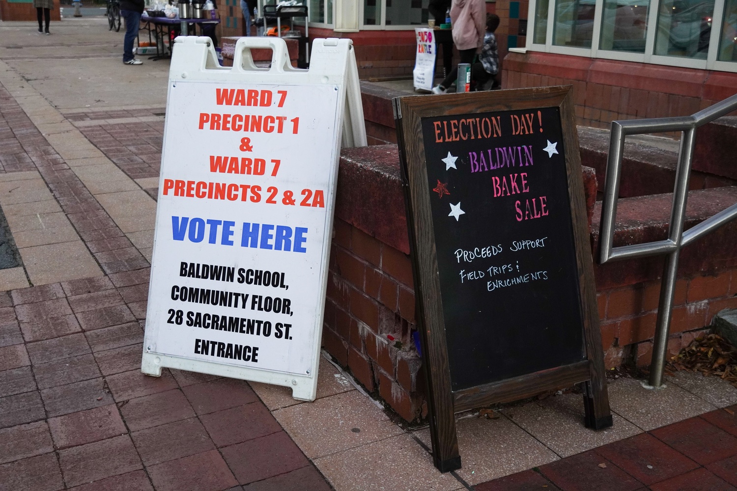 Signs outside of Baldwin School at 85 Oxford St encourage Cambridge residents to enter to vote in the Tuesday election.