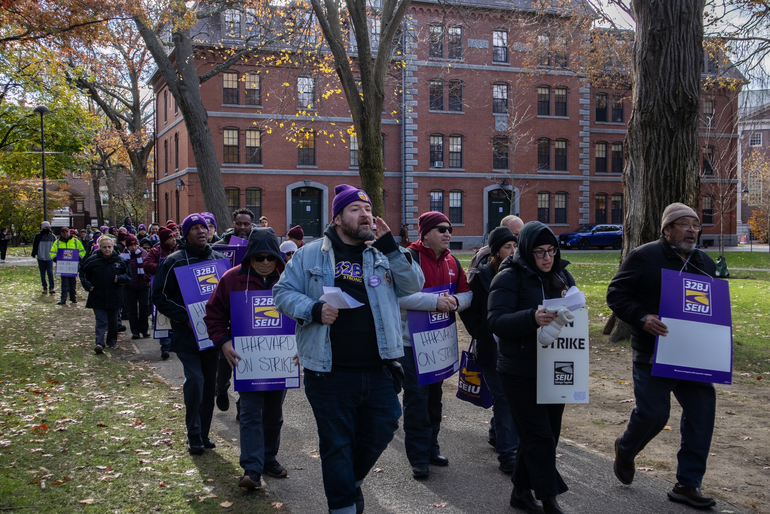 Custodians represented by the Service Employees International Union 32BJ march through Harvard Yard on Monday, the first day of their strike.