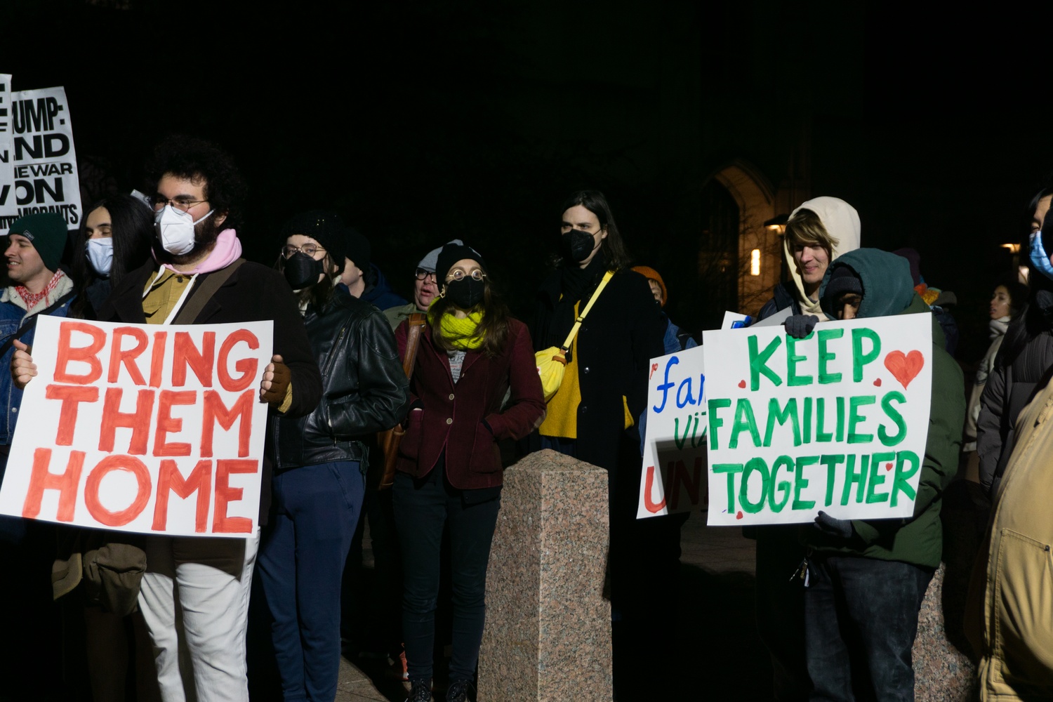 People hold signs at a Monday rally and vigil for nine immigrants who were arrested at a car wash in Allston, organized by the Boston Democratic Socialists of America and the LUCE Immigrant Justice Network of Massachusetts.
