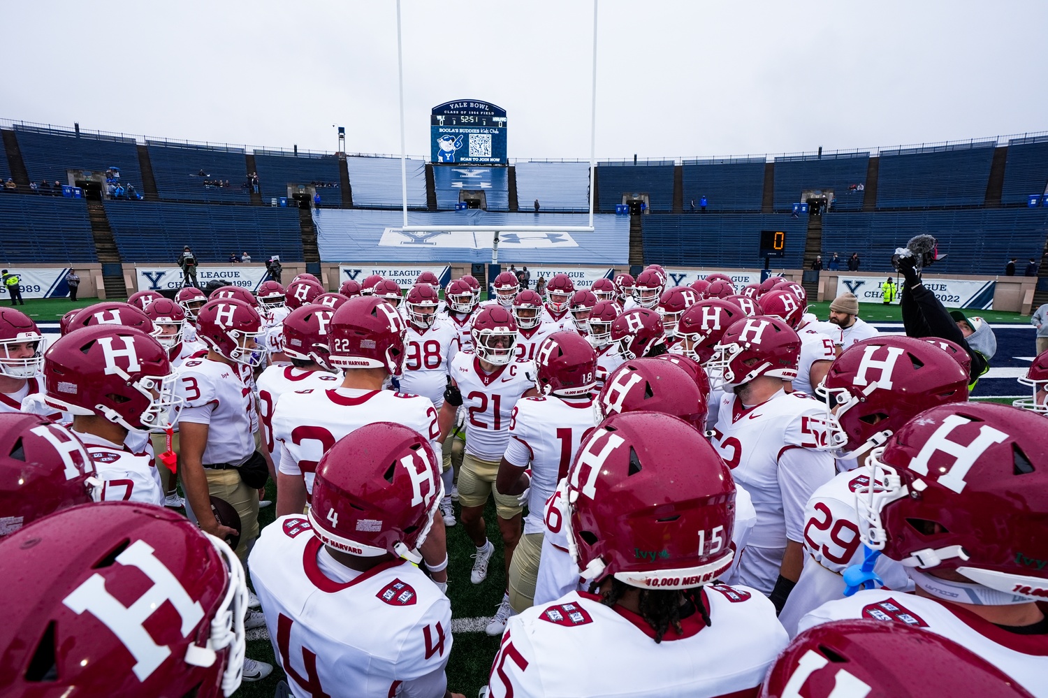 The Harvard football team huddles before the coin toss of the 141st playing of The Game.