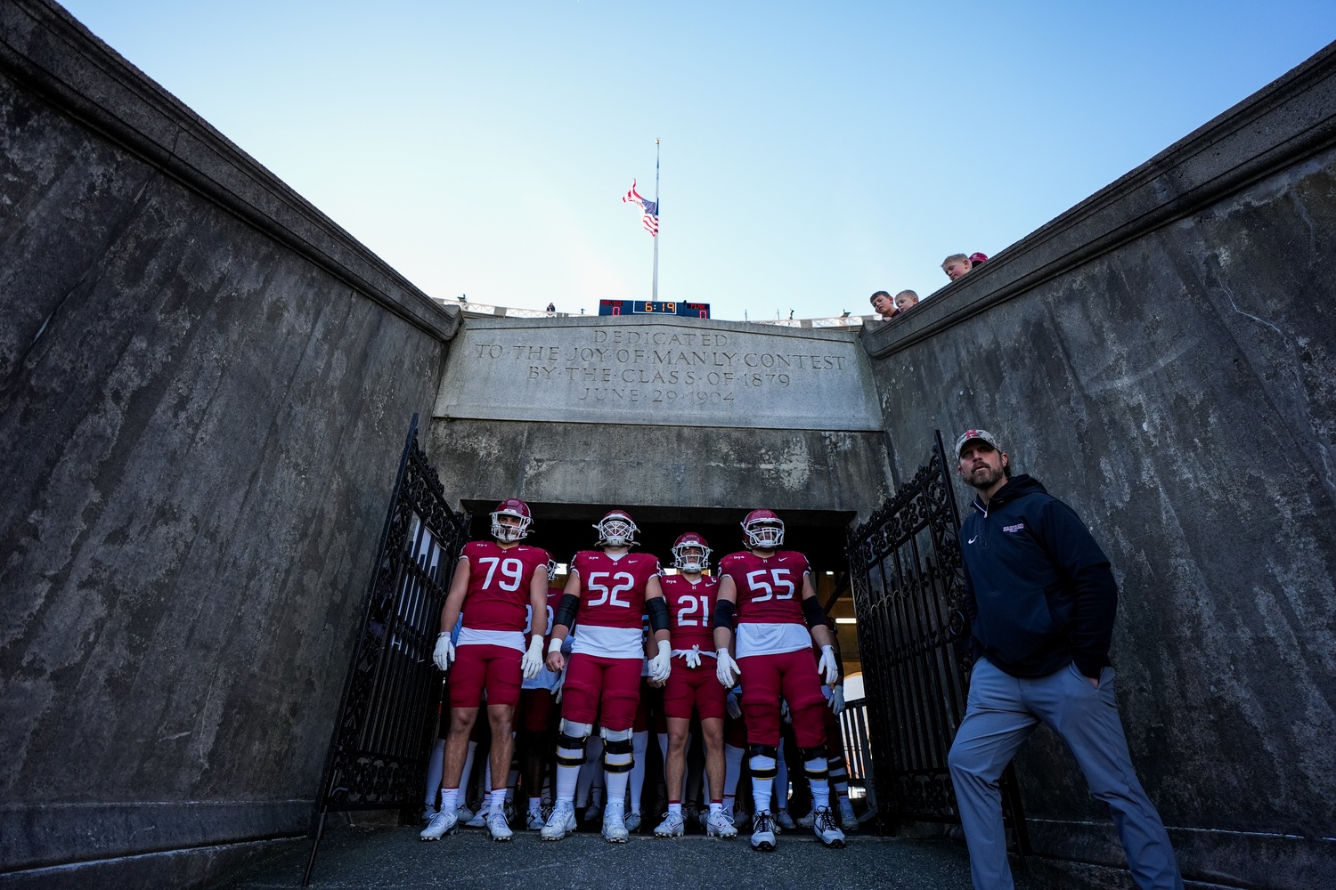 Head Coach Andrew Aurich leads the Crimson squad onto the field before a game against the University of Pennsylvania