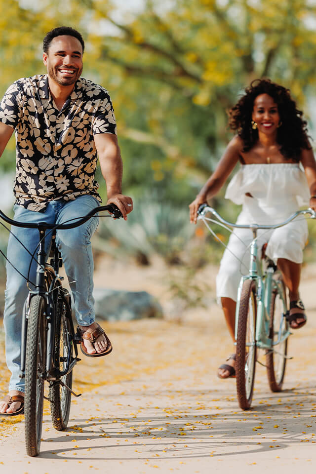 A couple riding bikes on a trail.
