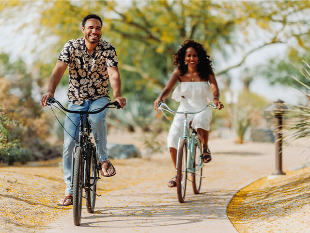 A couple riding bikes on a trail.