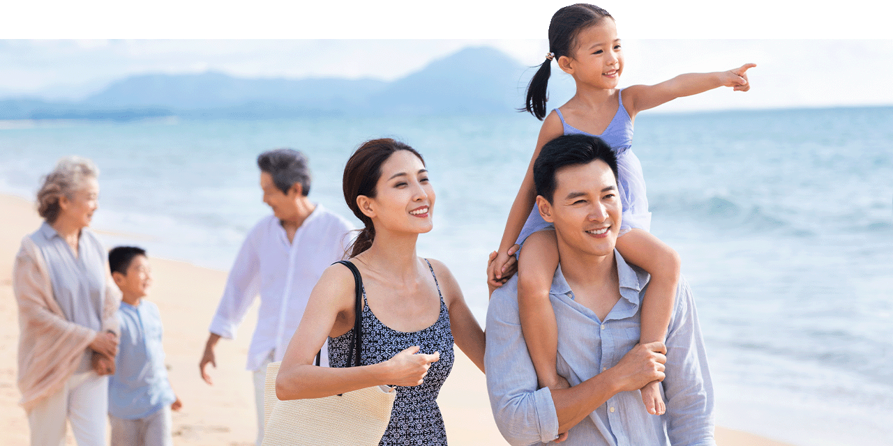 一家多代同堂的宾客在海滩漫步。