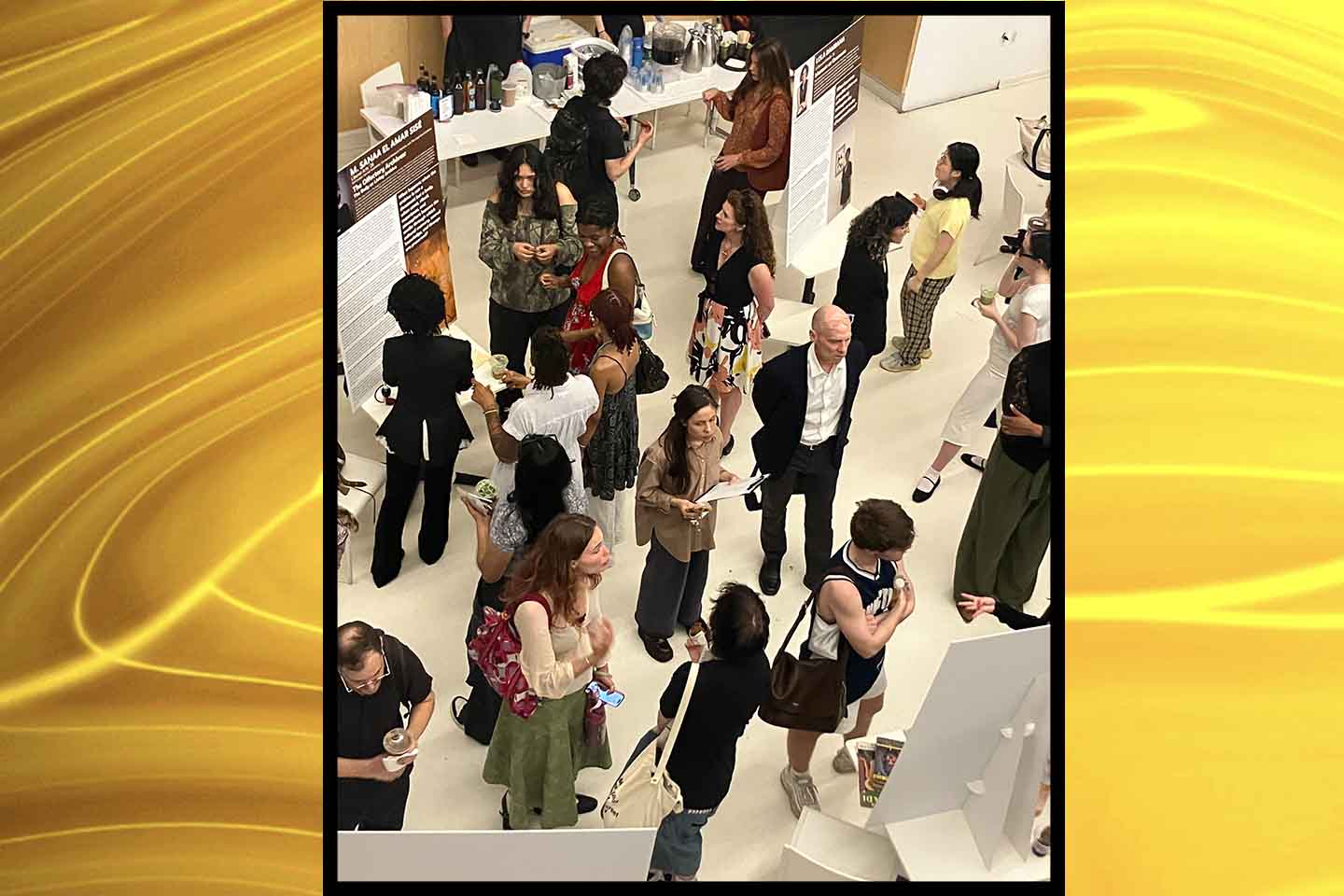 Students, faculty, and staff attend a session in which students discuss their work, presented in posters.