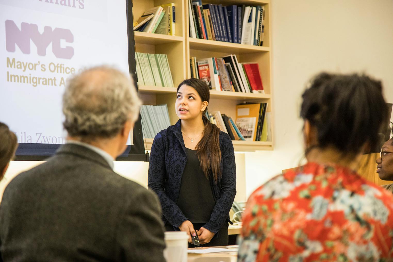 Person talks in a classroom in front of students.