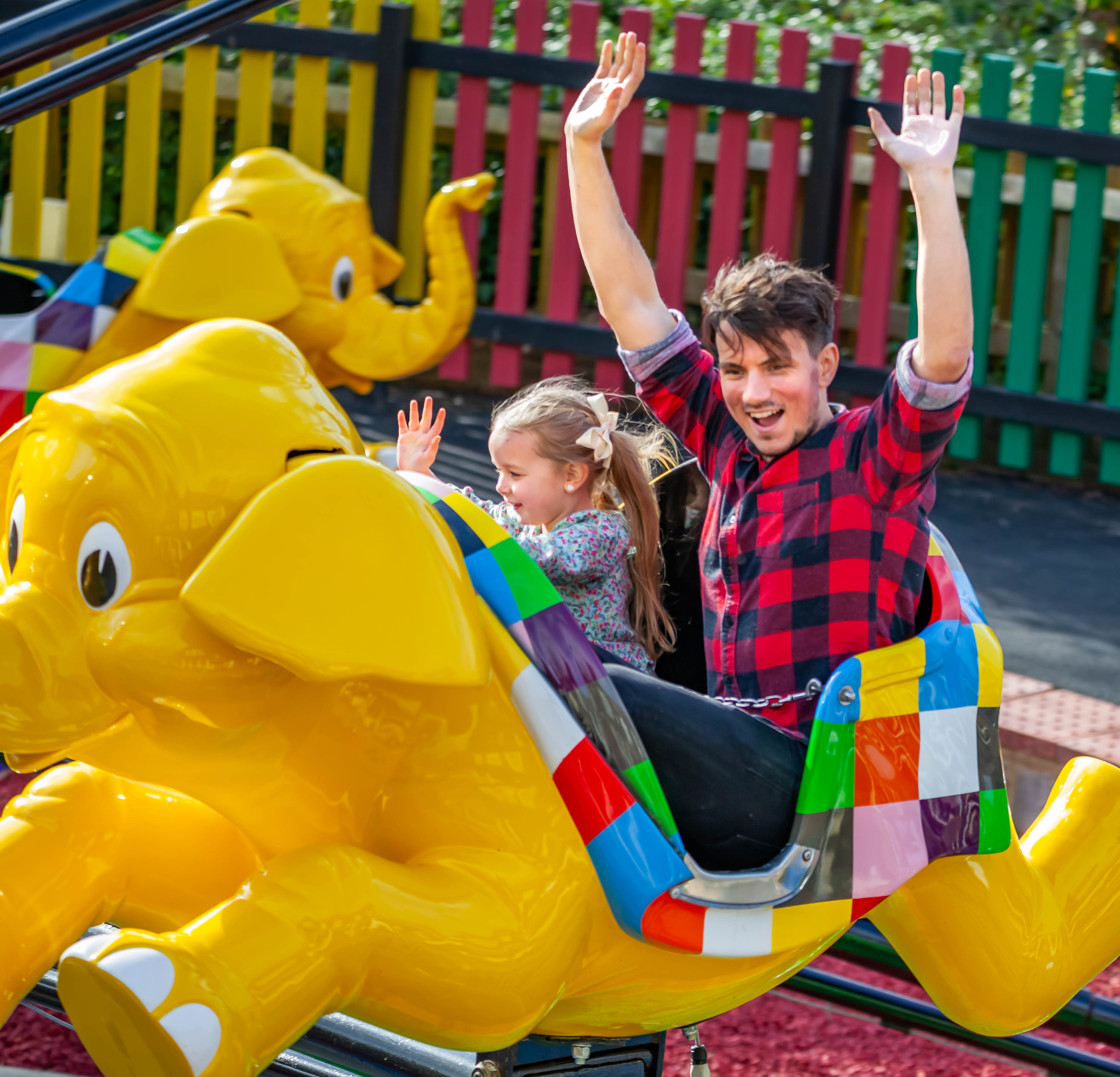 Father and daughter enjoying a colorful elephant ride at Chessington World of Adventures Resort.