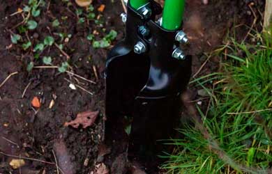 A hole digger entering the soil