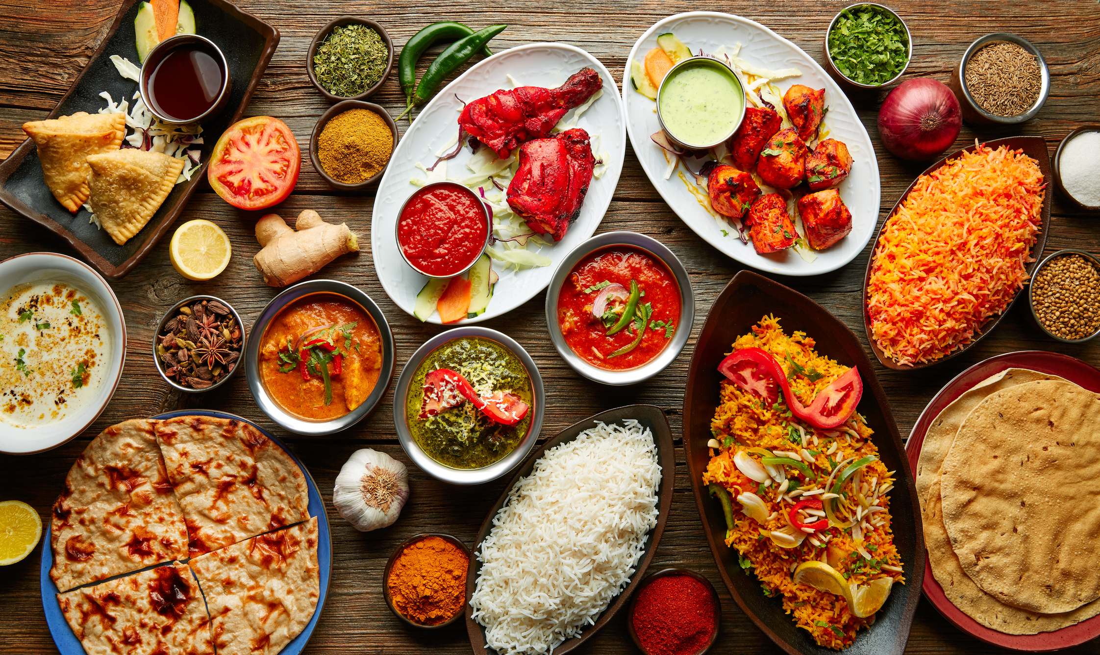 Assorted Indian recipes food various with spices and rice on wooden table in India.
