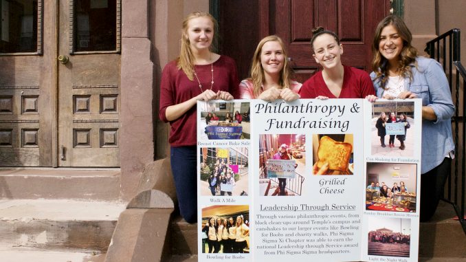 Processed with VSCOcam with c1 preset Rachel Makar (left), Mackenzie Blue, Lauren Ravitch and Tori Cuccurullo display a poster detailing Phi Sigma Sigma’s philanthropy events for Oct. 5-8. | Joshua Dicker TTN
