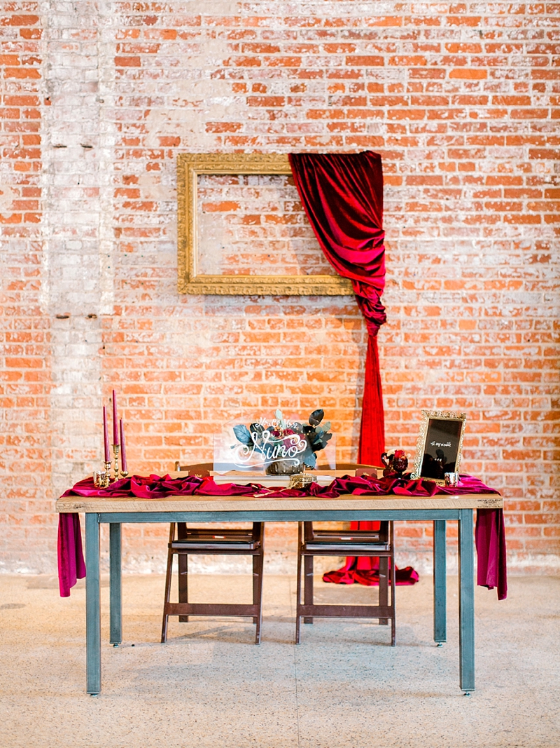 Elegant asymmetrical red velvet draping on gold frame for wedding backdrop