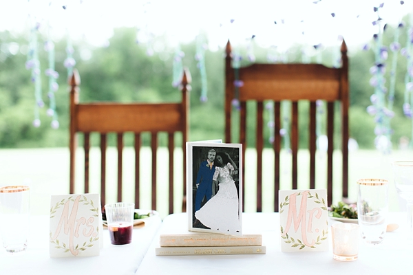 Wedding sweetheart table with fun photo of bride and groom wearing paper doll clothes