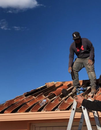 residential roofing Tucson working on a tile roof on a Tucson home